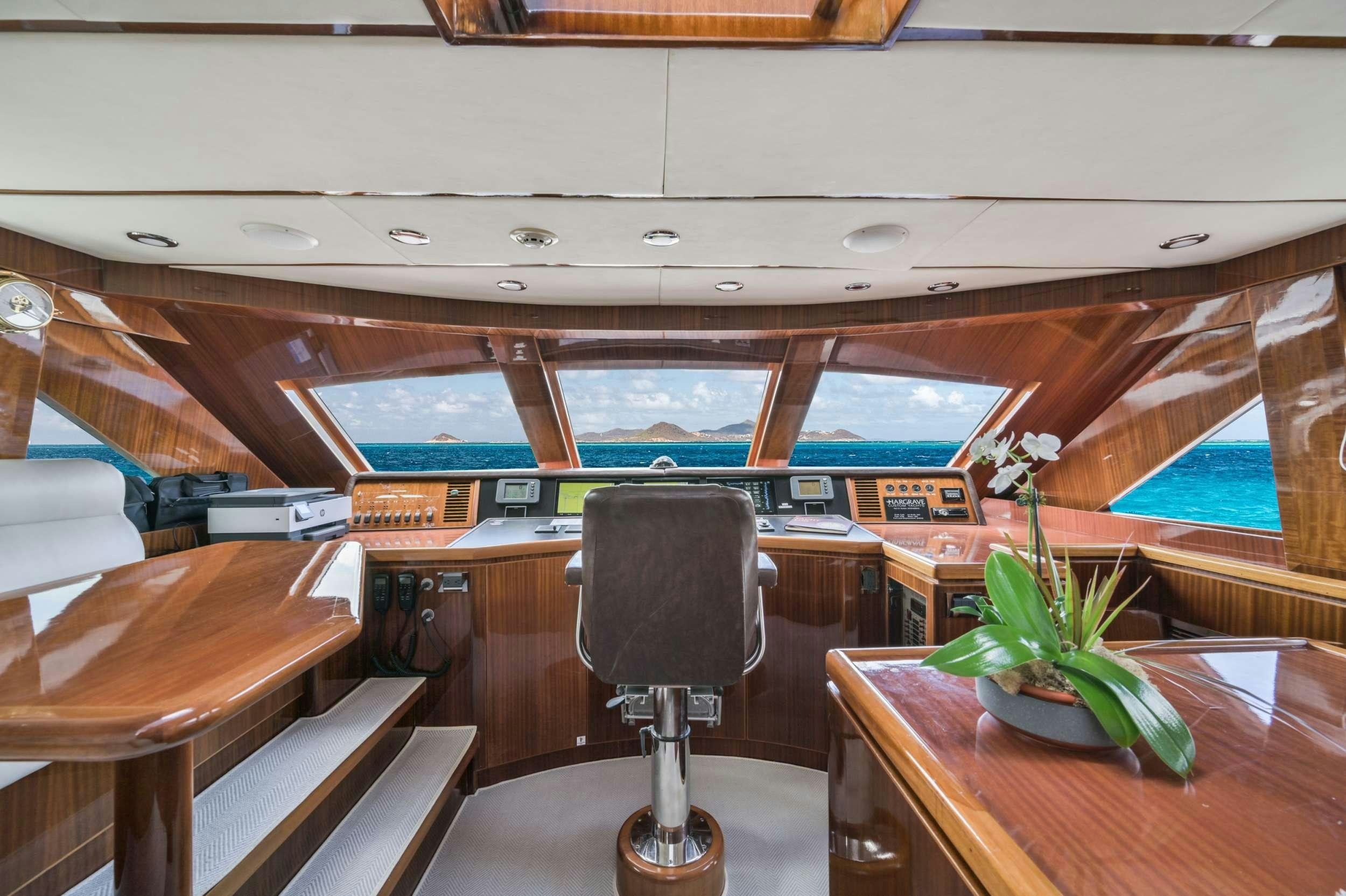 inside of a building with a table and chairs and plants aboard LIMITLESS Yacht for Charter