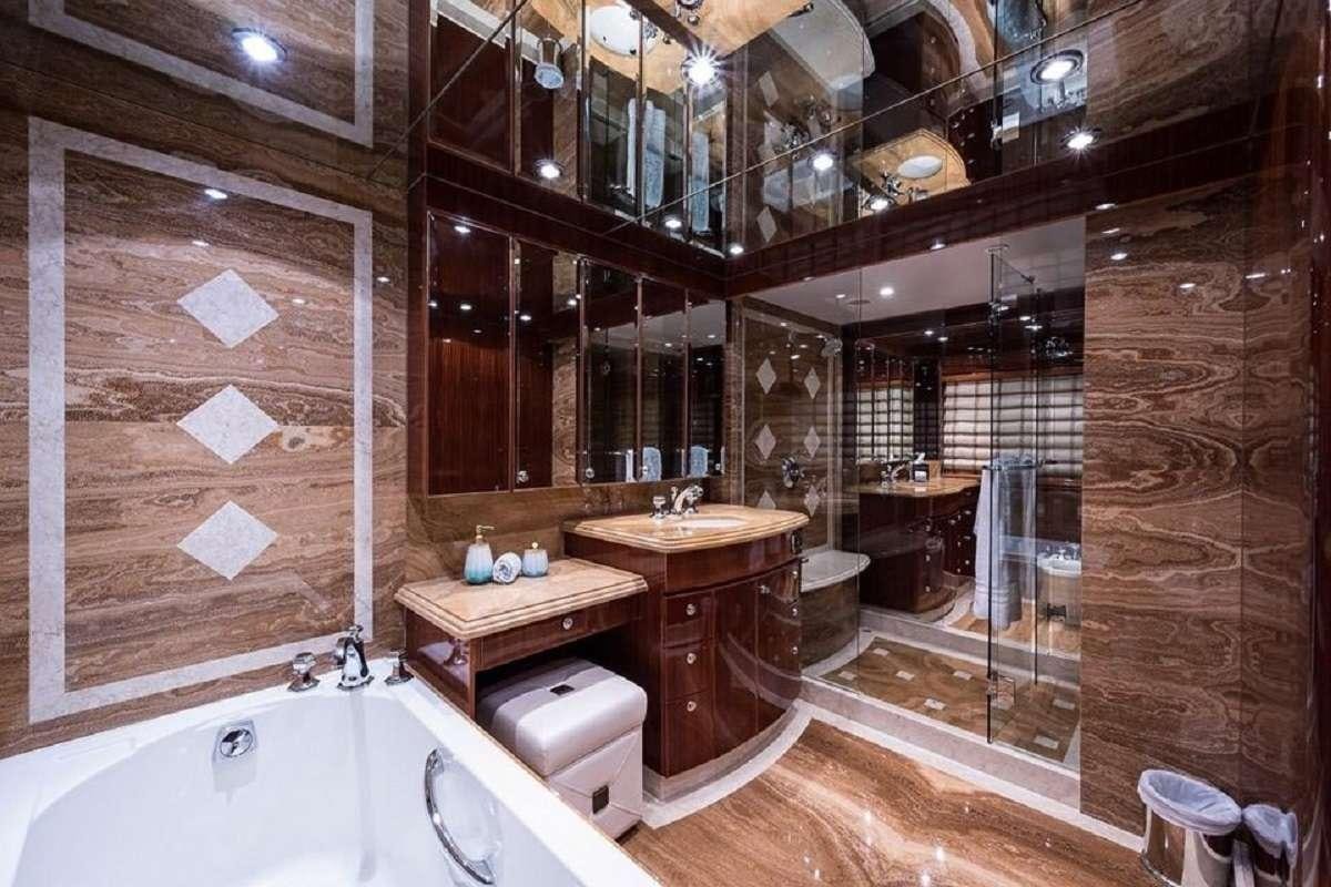 a bathroom with a tub sink and a mirror aboard LIMITLESS Yacht for Charter