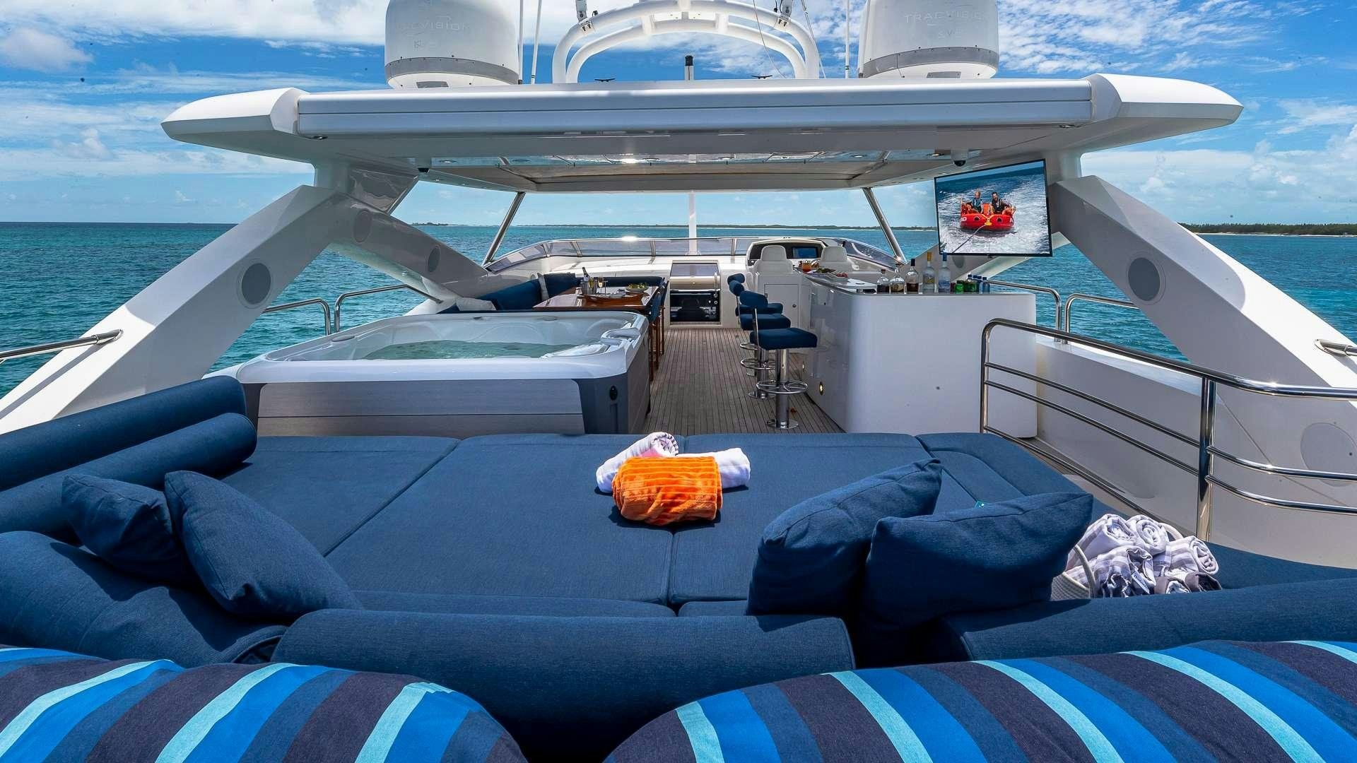 a boat with a blue cover and chairs on the deck aboard EMRYS Yacht for Charter
