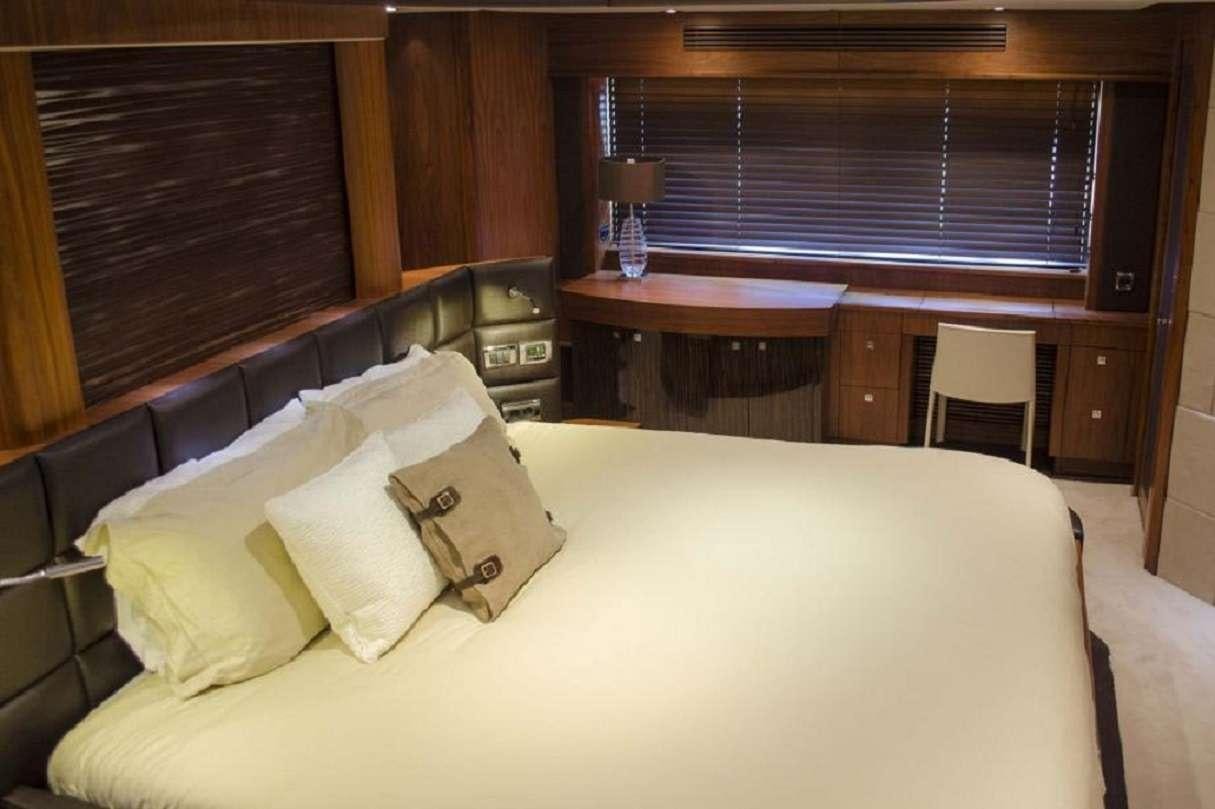 a bed with a white sheet and pillows aboard EMRYS Yacht for Charter