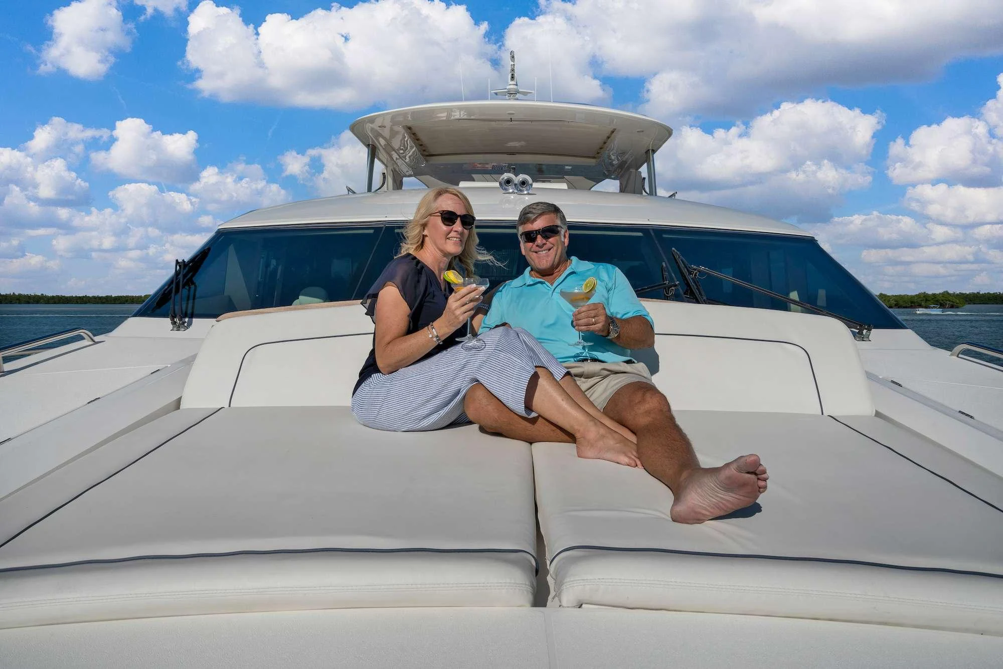 a man and woman sitting on a boat with water and sky aboard CURRENT $EA Yacht for Charter