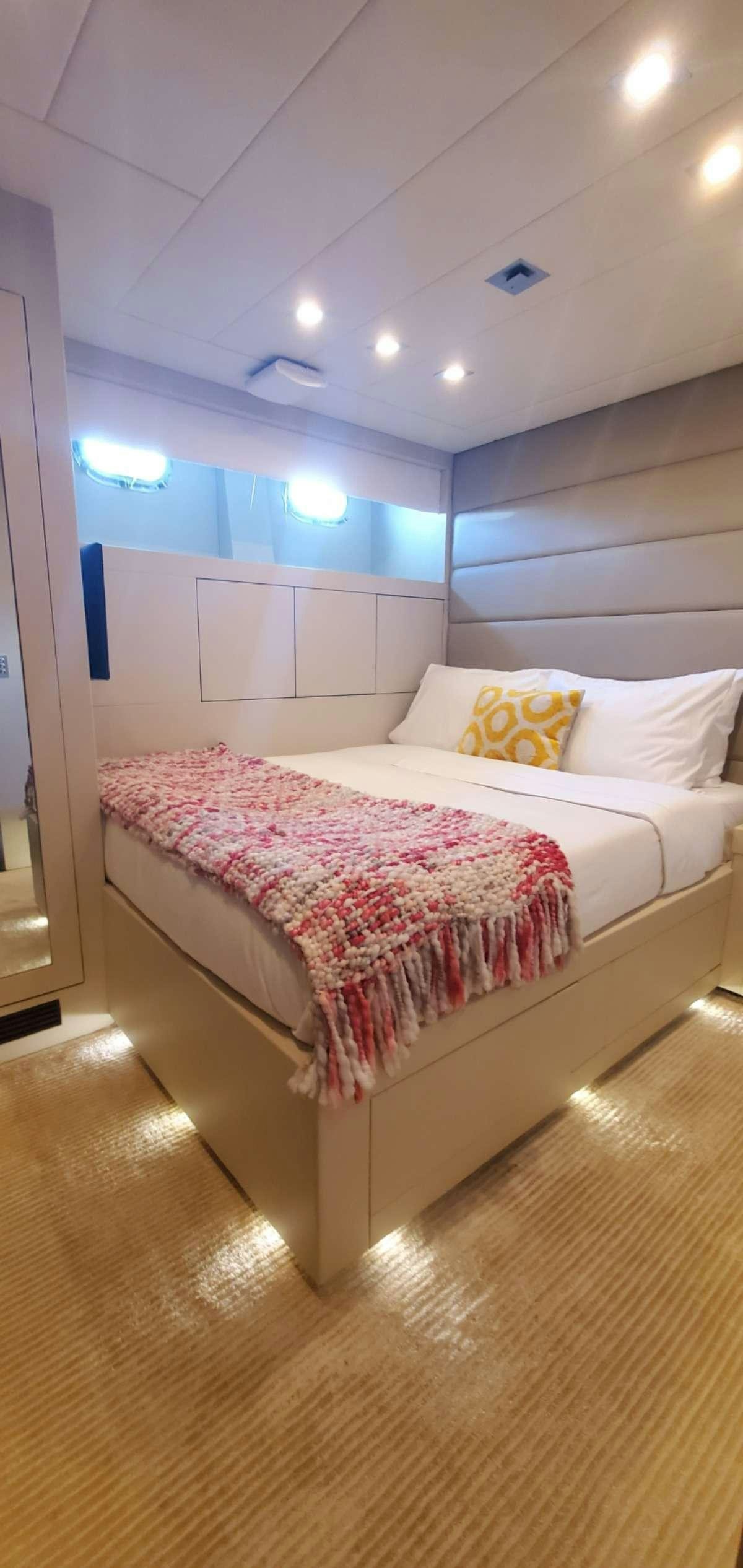 a bed with a pink comforter aboard HOUDINI Yacht for Charter