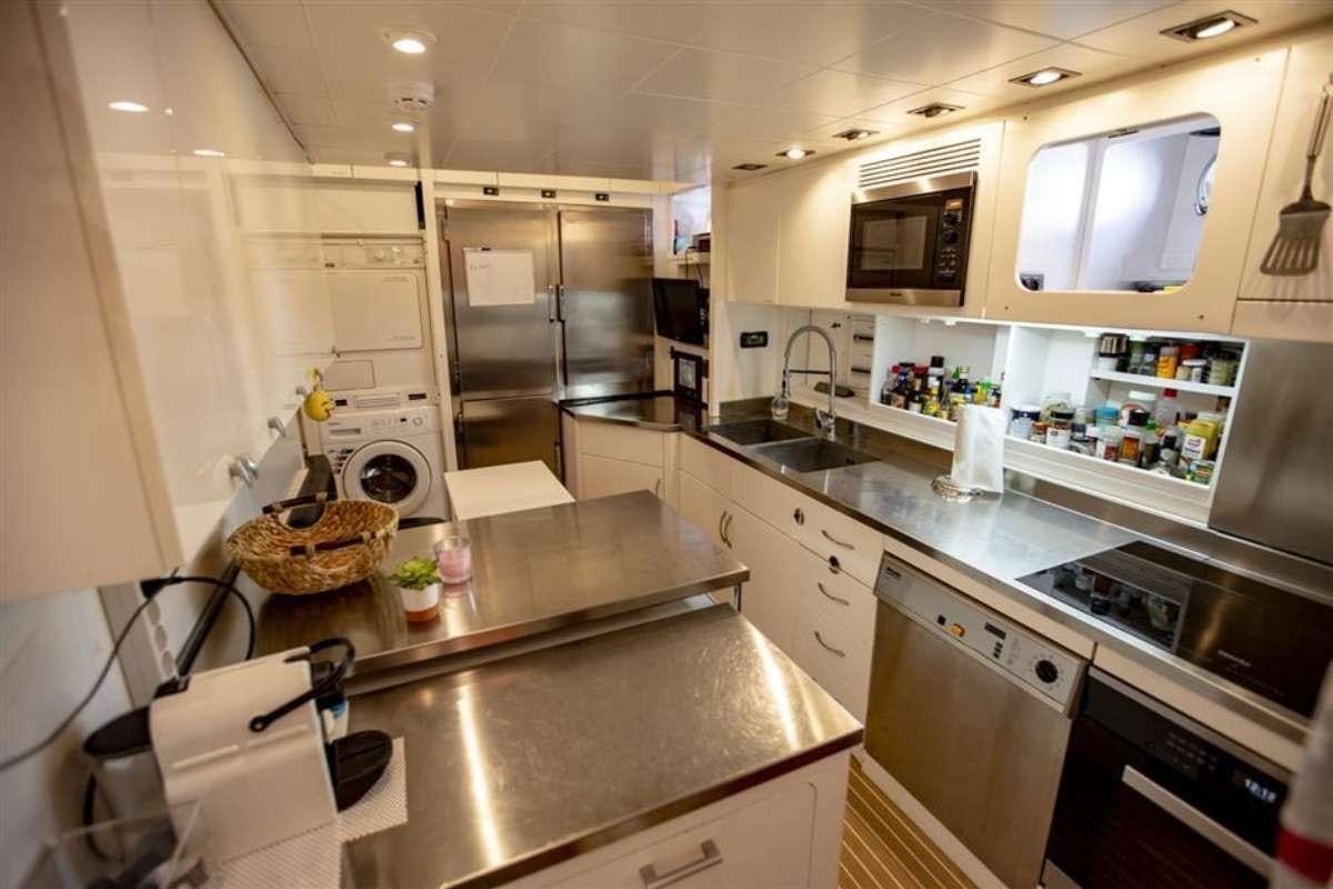 a kitchen with white cabinets aboard EVA Yacht for Charter