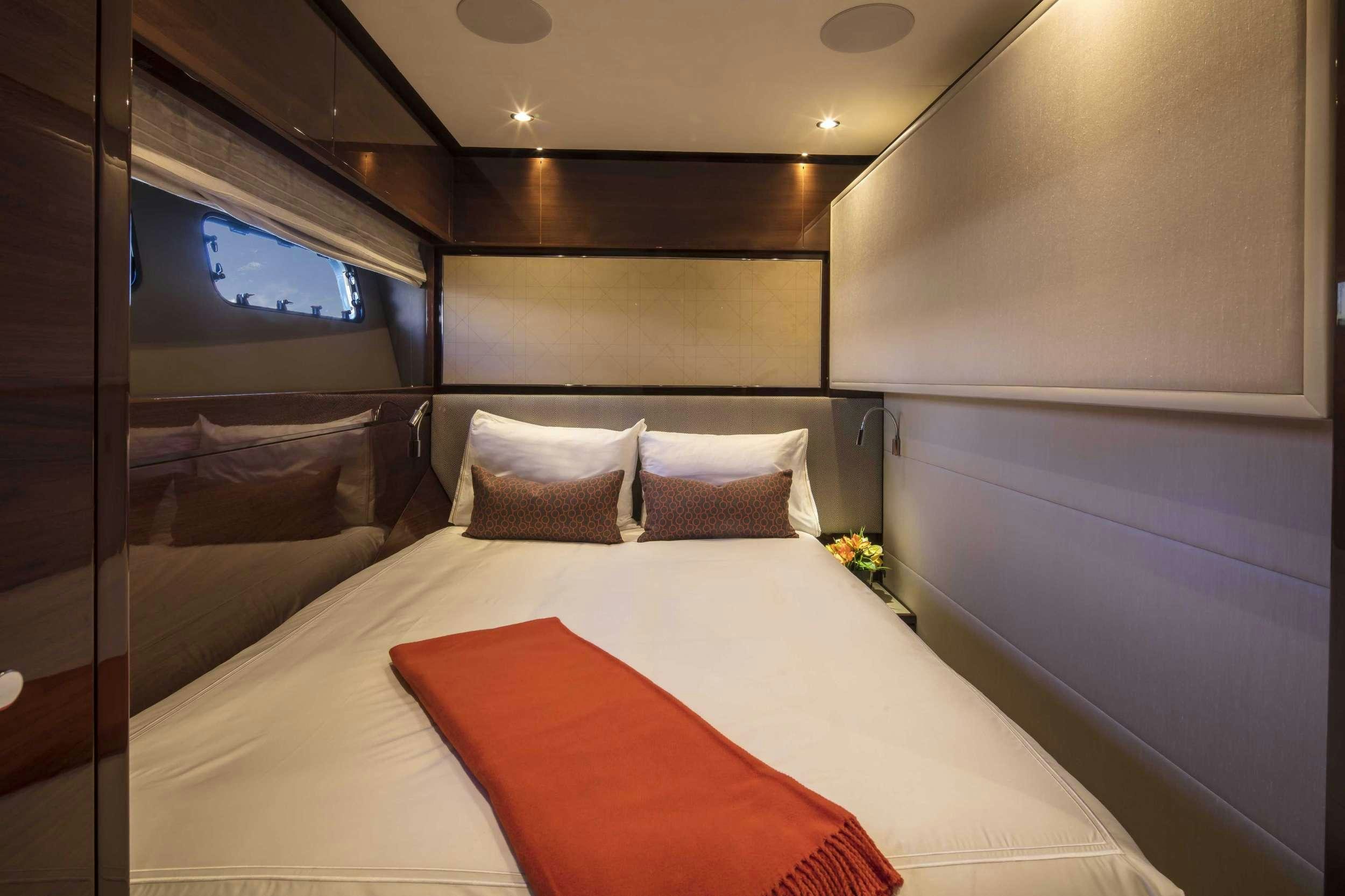 a bed with a red pillow aboard HOT PURSUIT Yacht for Charter