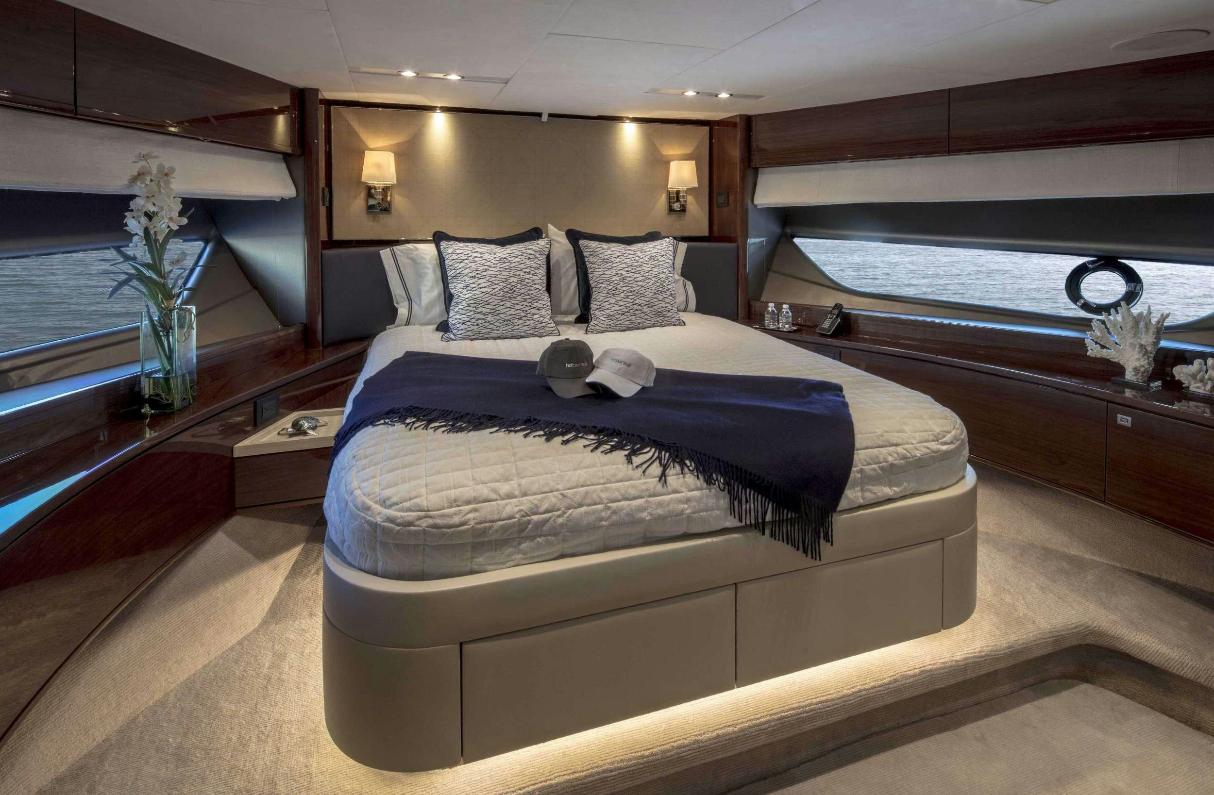 a bed with a blue comforter aboard HOT PURSUIT Yacht for Charter