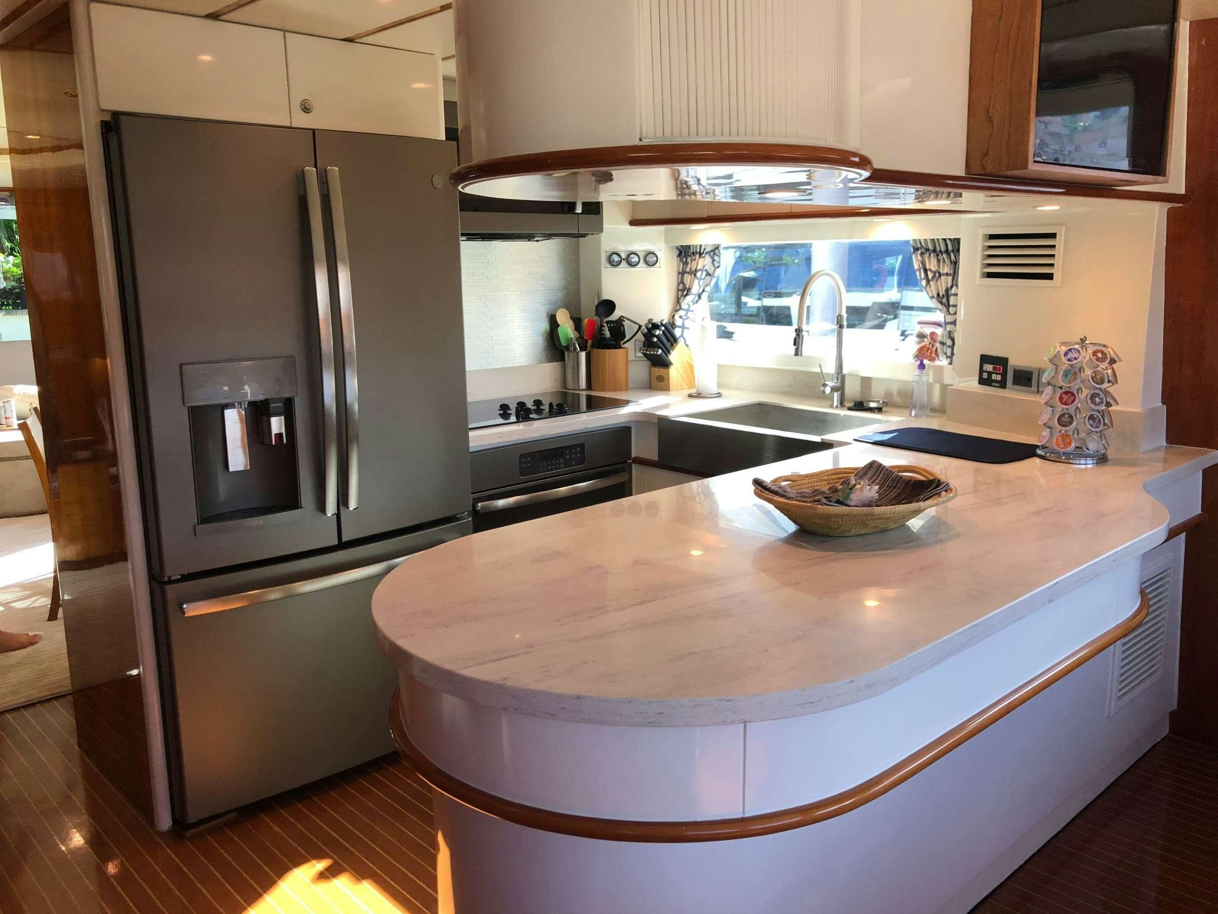 a kitchen with a stainless steel refrigerator aboard TORTUGA Yacht for Charter