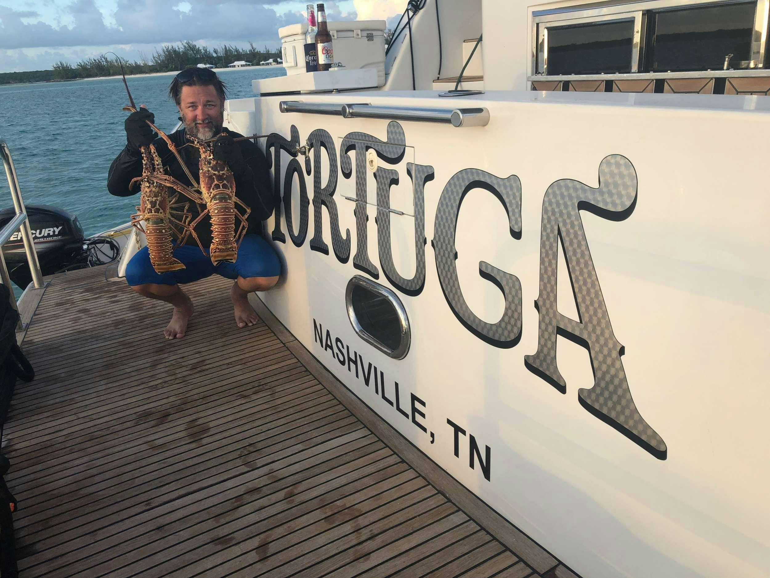 a person sitting on a boat holding a guitar aboard TORTUGA Yacht for Charter