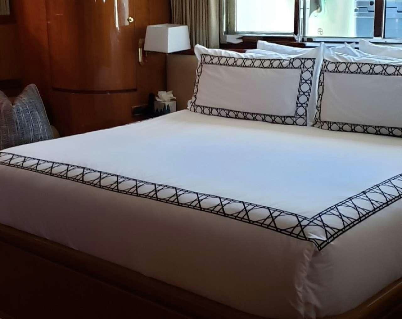 a bed with white sheets aboard TORTUGA Yacht for Charter