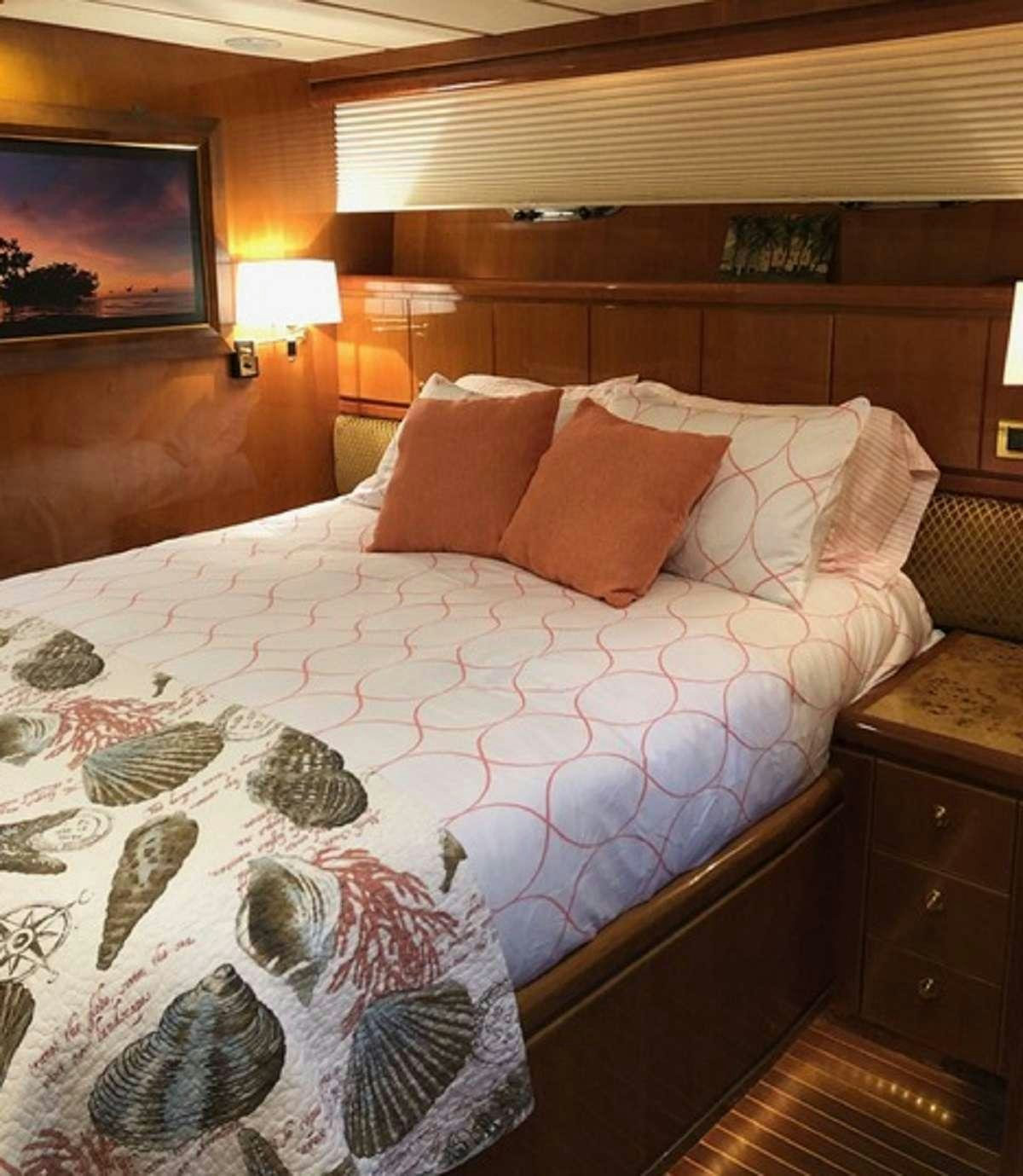 a bed with a white comforter and pillows aboard TORTUGA Yacht for Charter