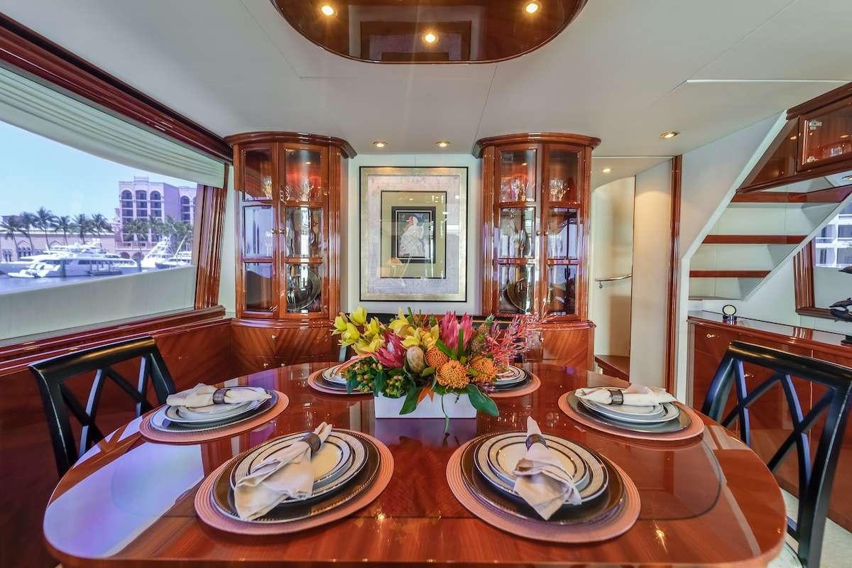 a dining table with plates and flowers aboard COPAY Yacht for Charter