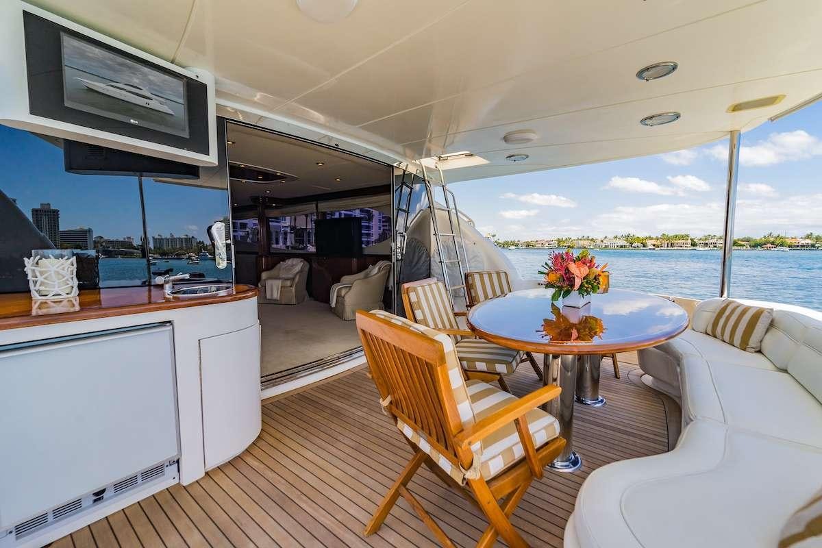 a room with a table chairs and a television on the wall aboard COPAY Yacht for Charter