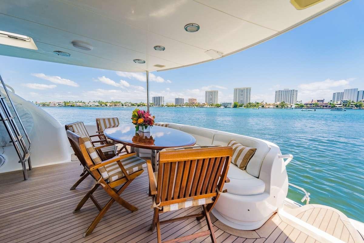 a table and chairs on a deck overlooking a city aboard COPAY Yacht for Charter