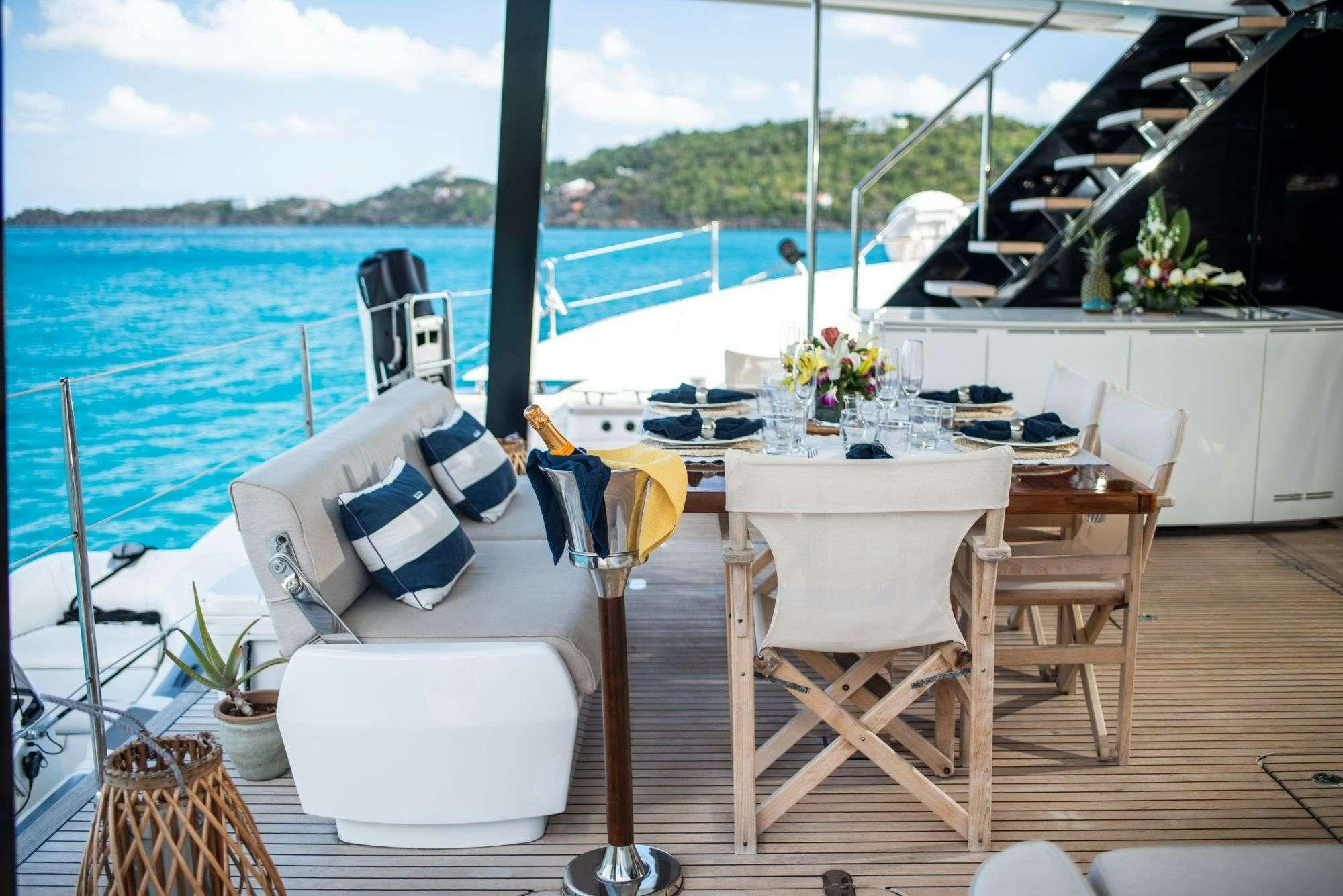 a table and chairs on a deck overlooking a body of water aboard BUNDALONG Yacht for Charter