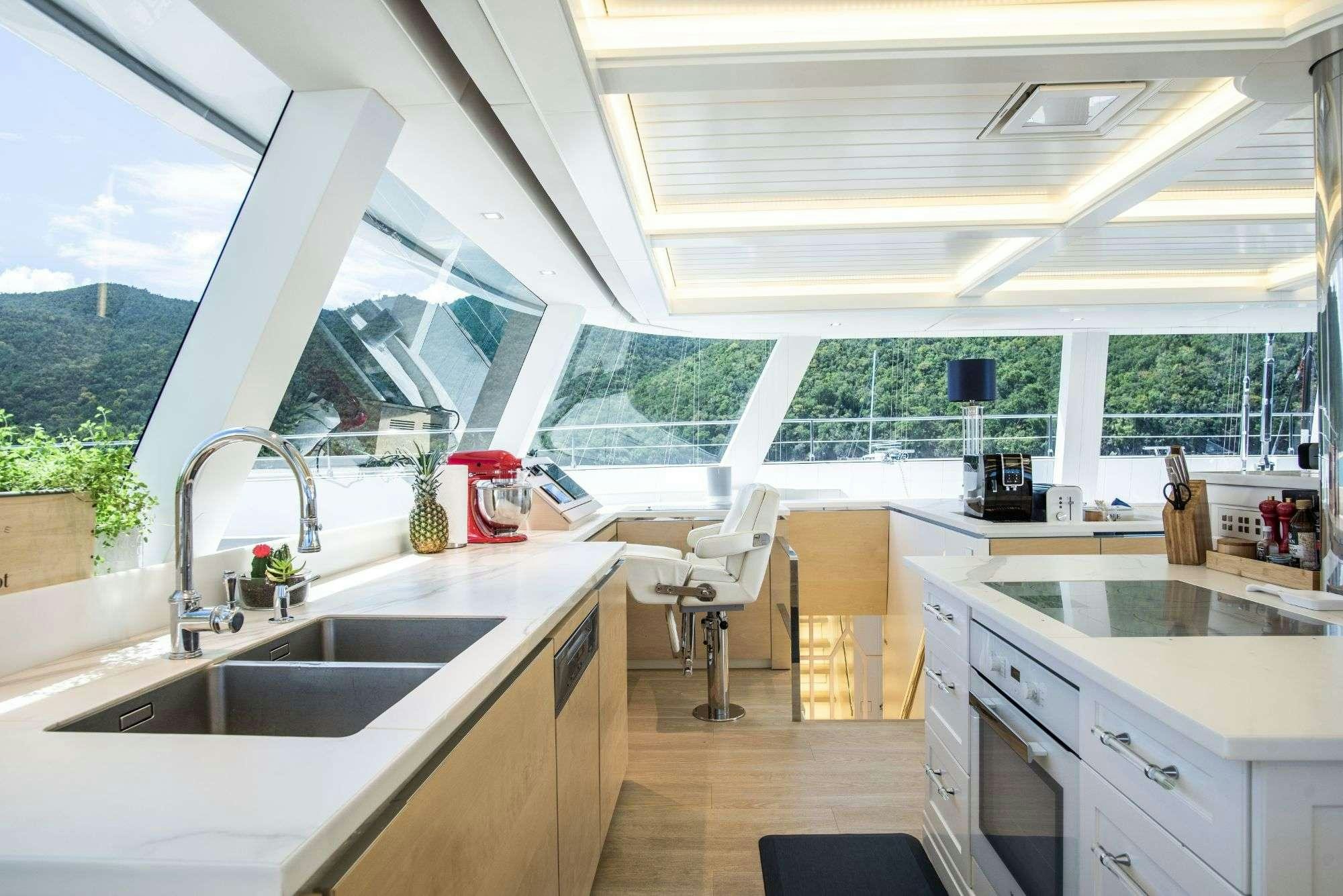 a kitchen with a large window aboard BUNDALONG Yacht for Charter