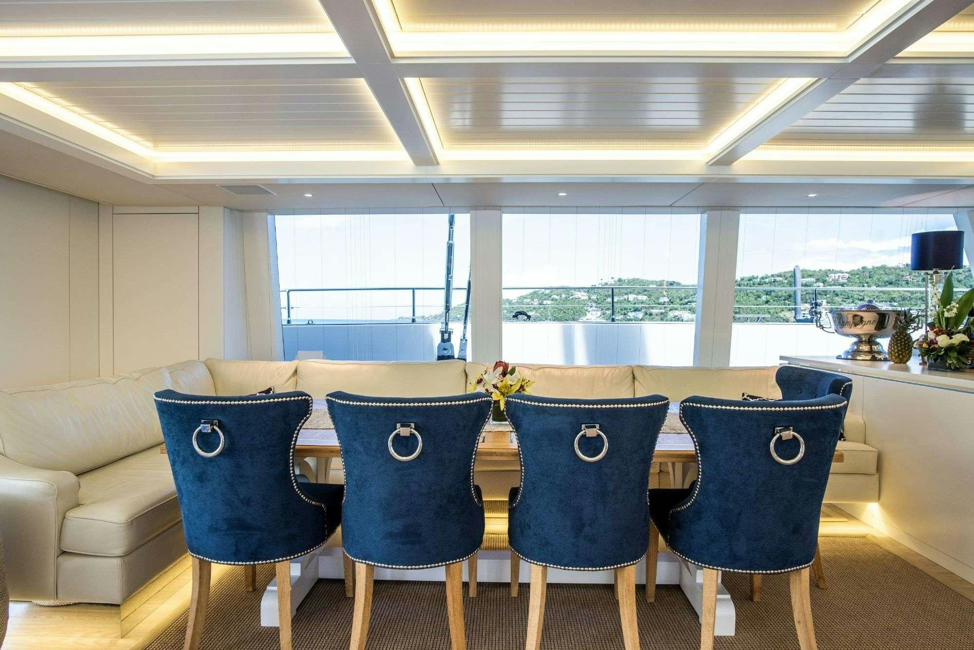 a dining room with blue chairs aboard BUNDALONG Yacht for Charter