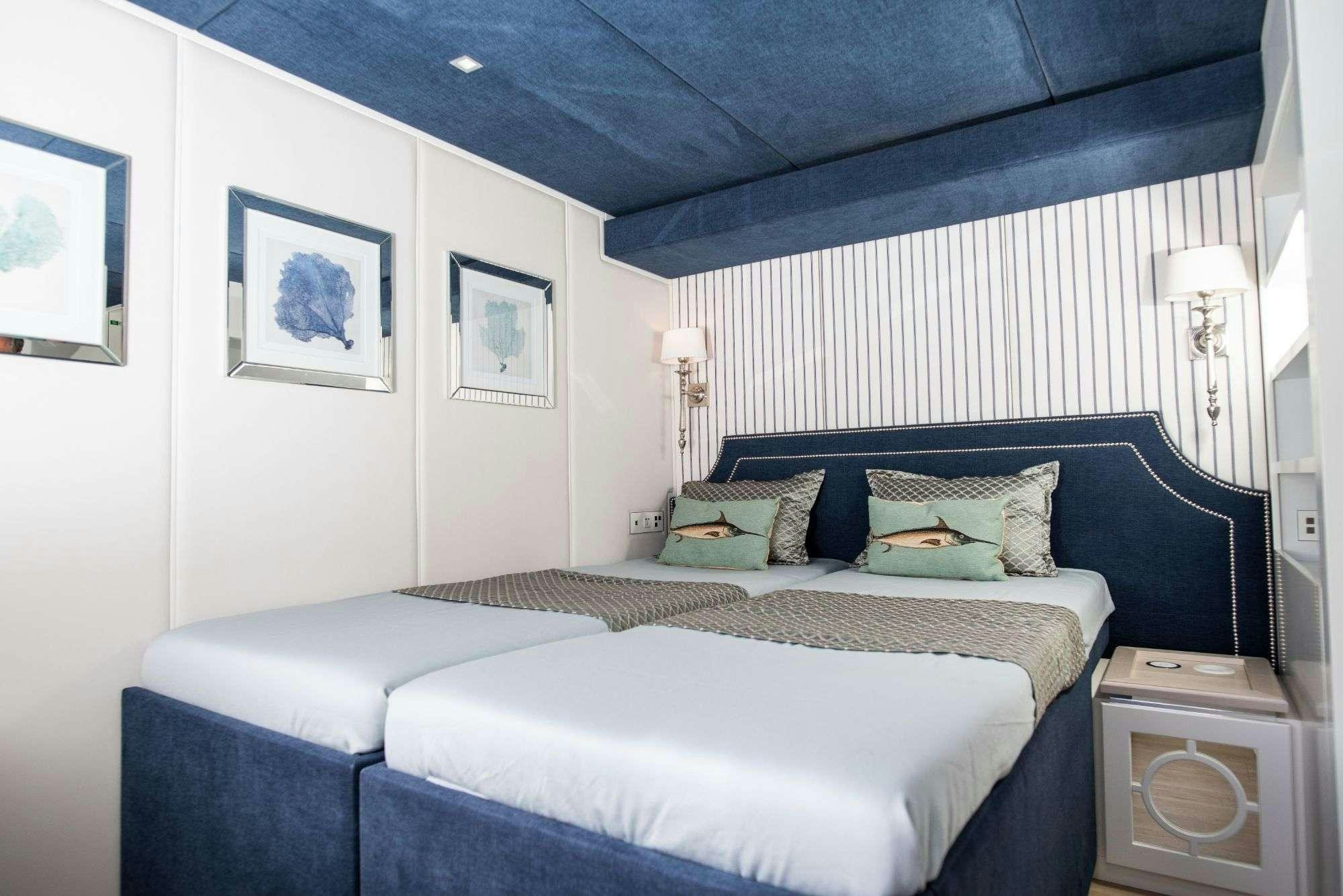 a bedroom with a bed and a lamp aboard BUNDALONG Yacht for Charter