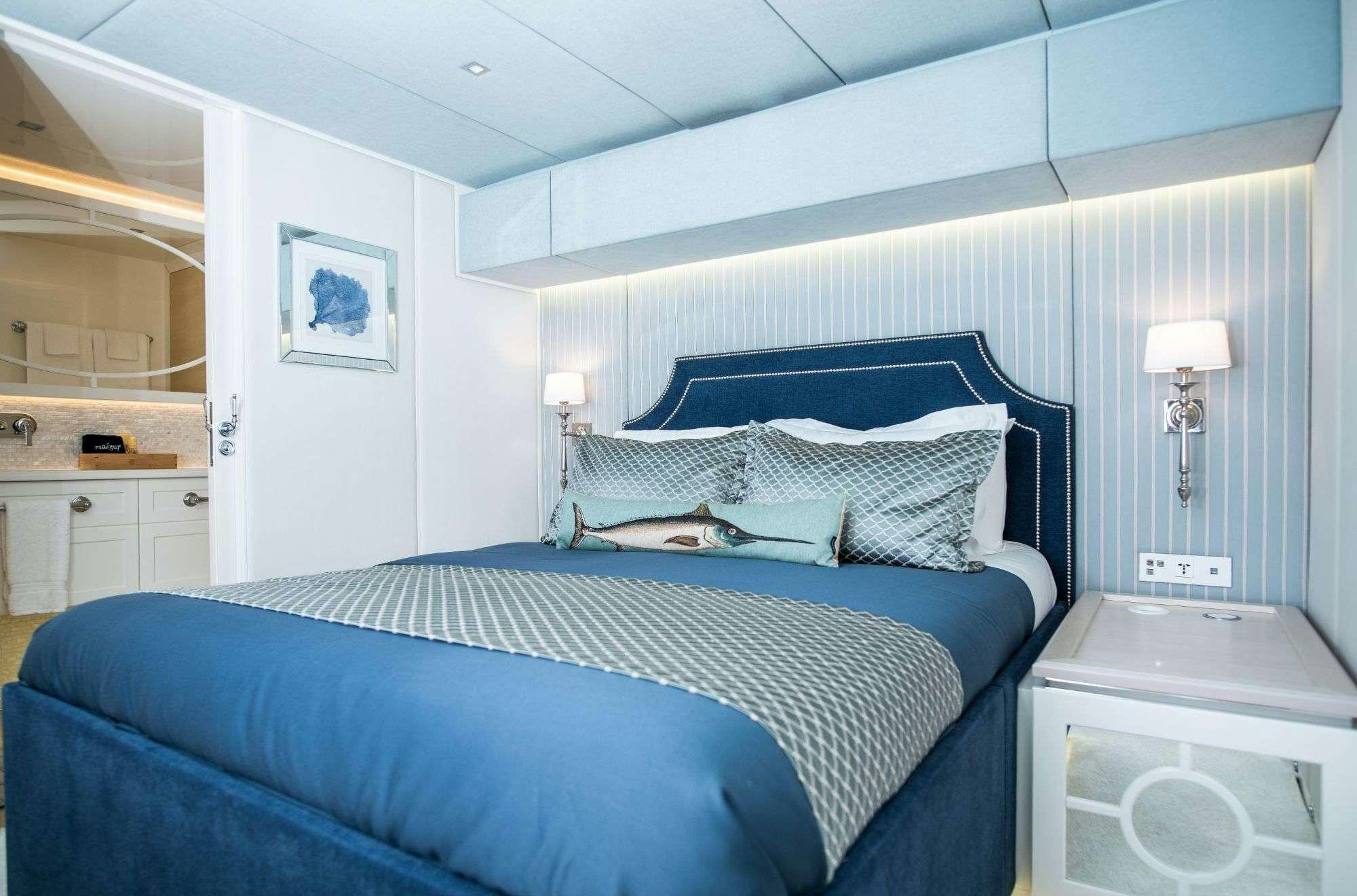 a bedroom with a blue bed aboard BUNDALONG Yacht for Charter