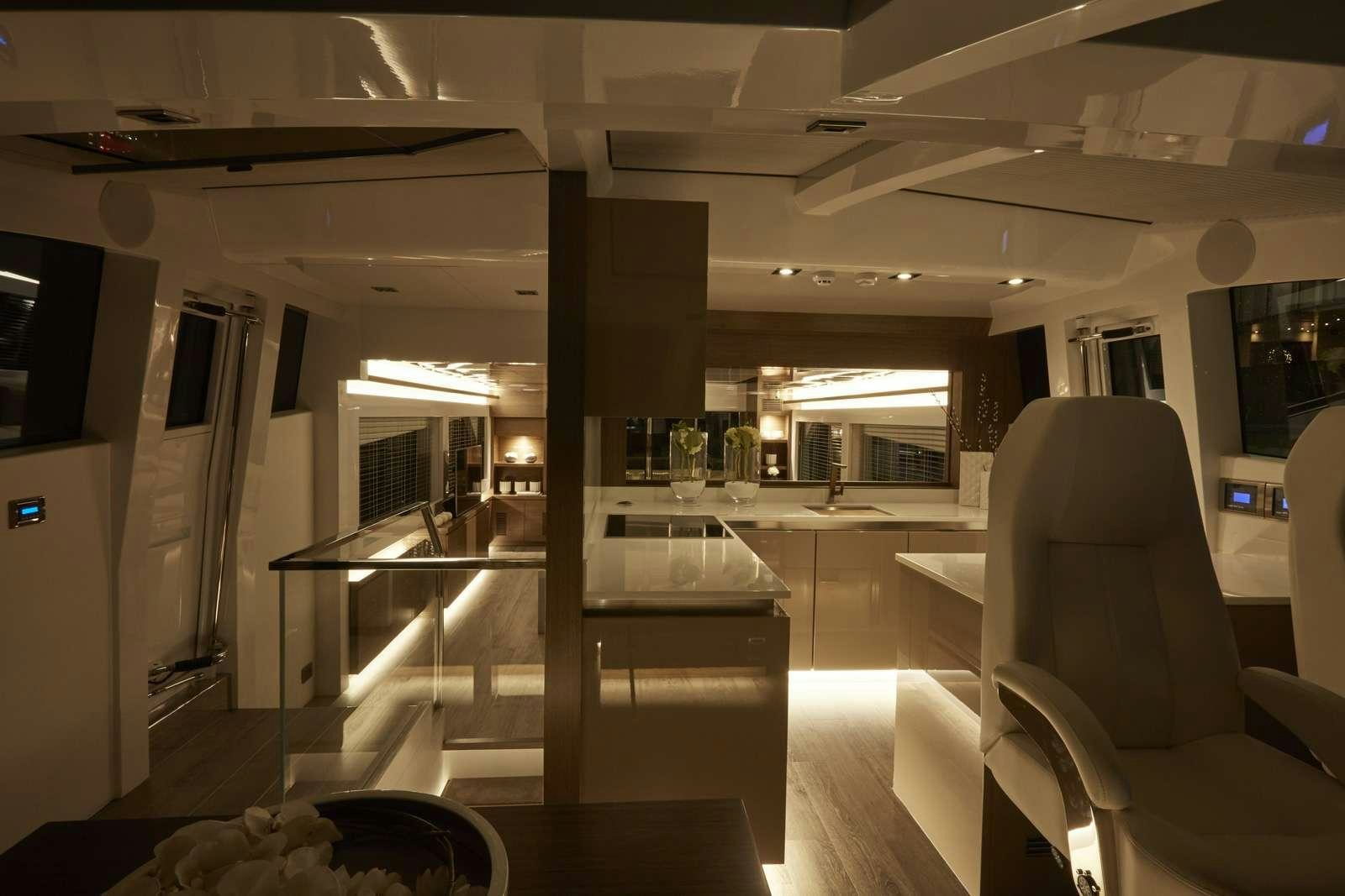 a room with a glass door and a table with chairs aboard pearl Yacht for Charter