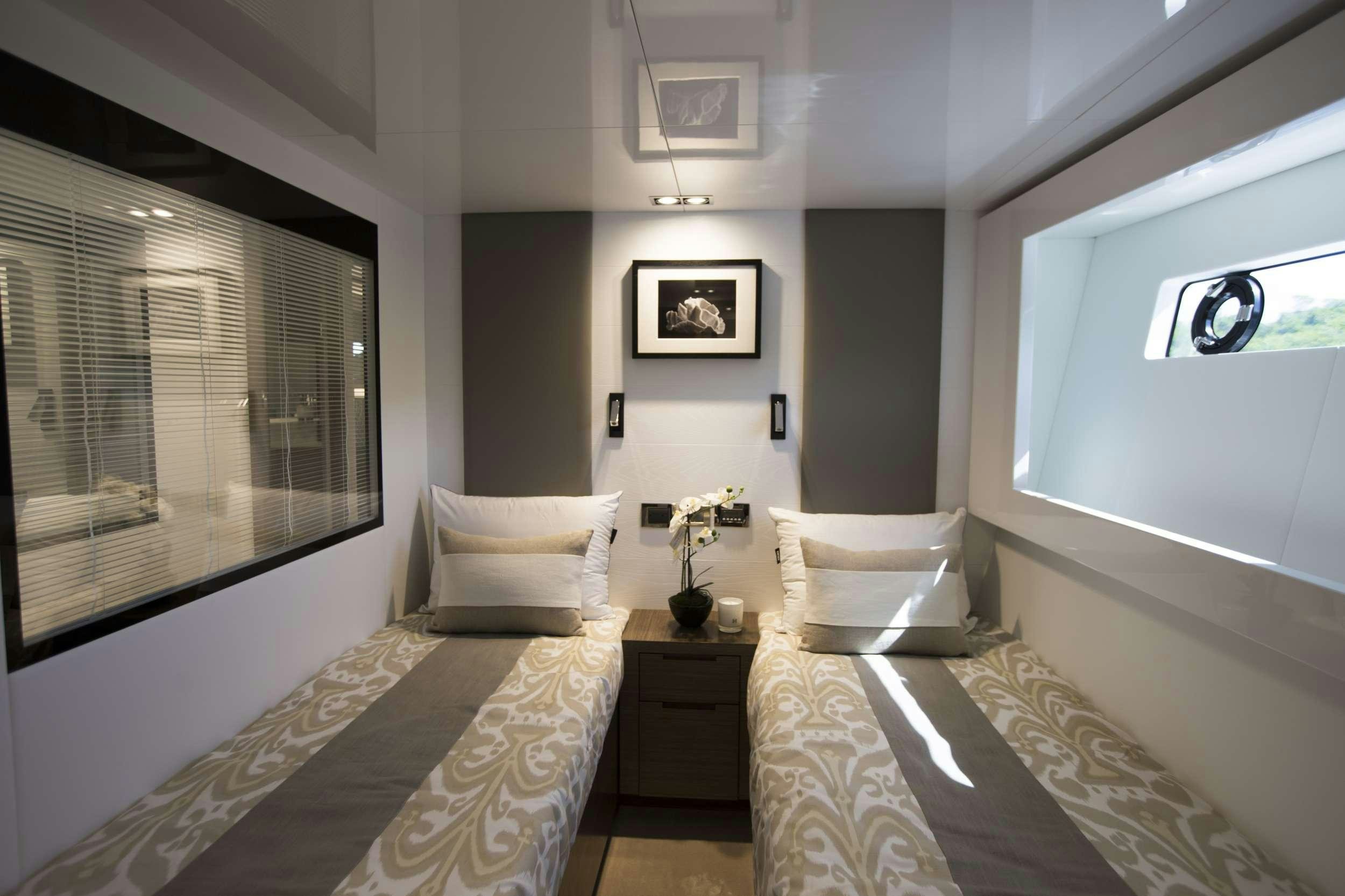 a bedroom with a bed and a window aboard pearl Yacht for Charter