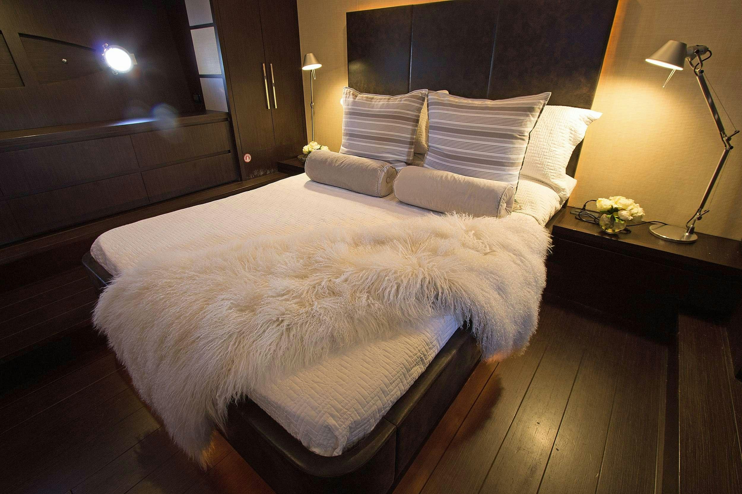 a bed with white sheets aboard SHOWBOAT Yacht for Charter