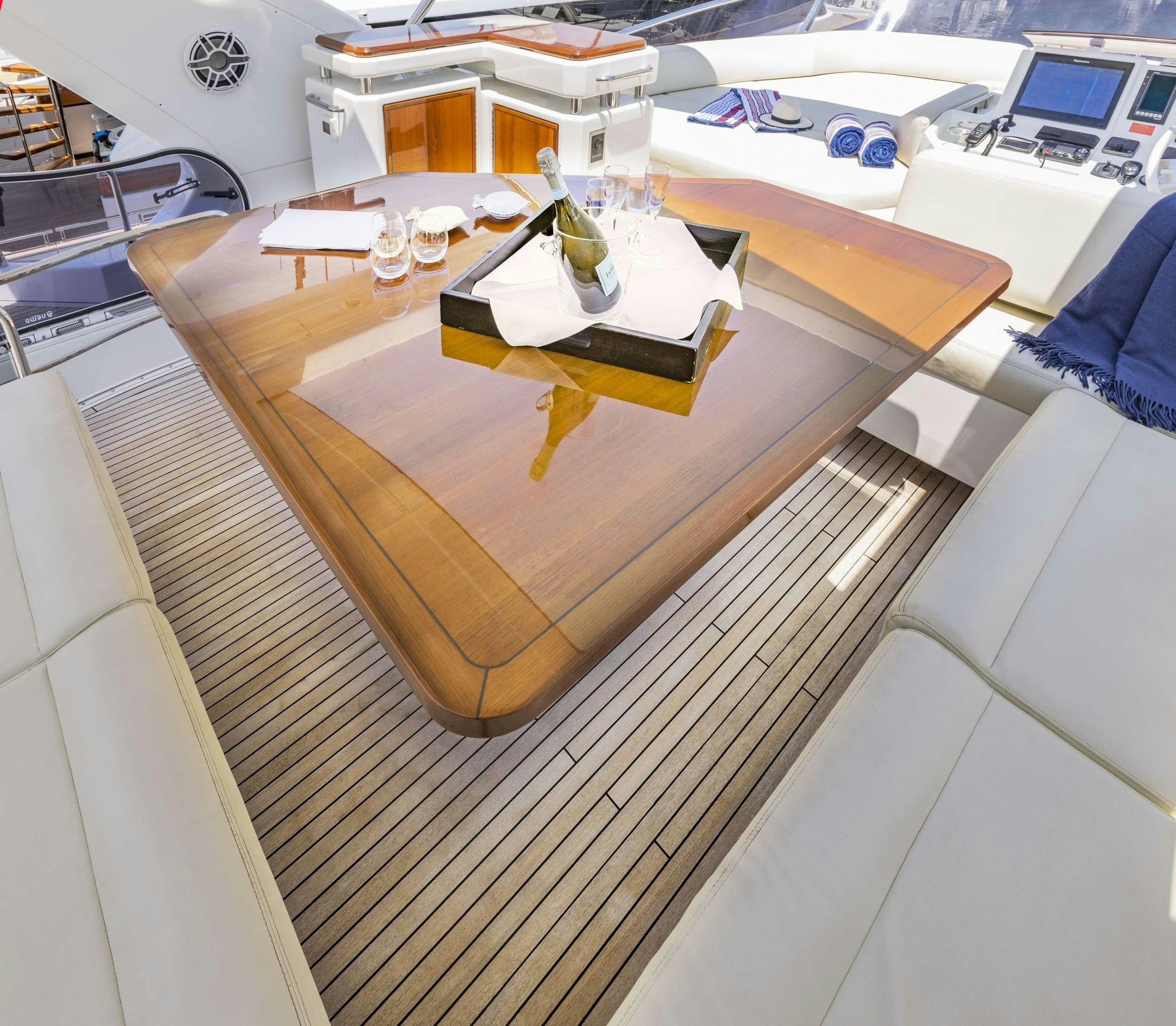 a wooden table with a glass top aboard DESSERT FIRST Yacht for Charter