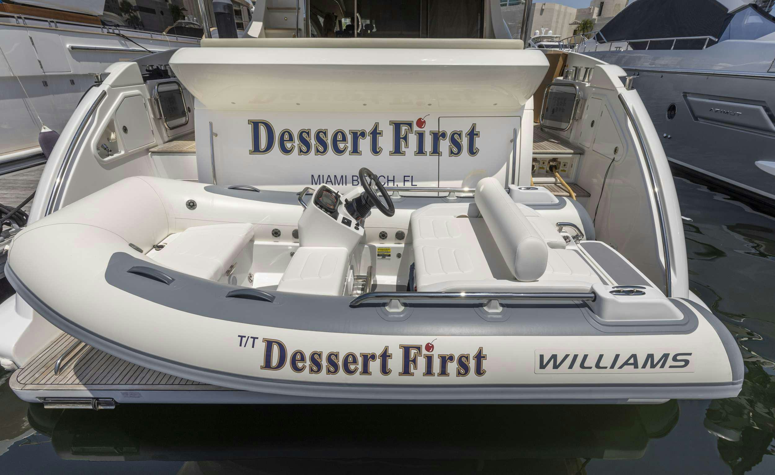 a white boat with a sign on it aboard DESSERT FIRST Yacht for Charter