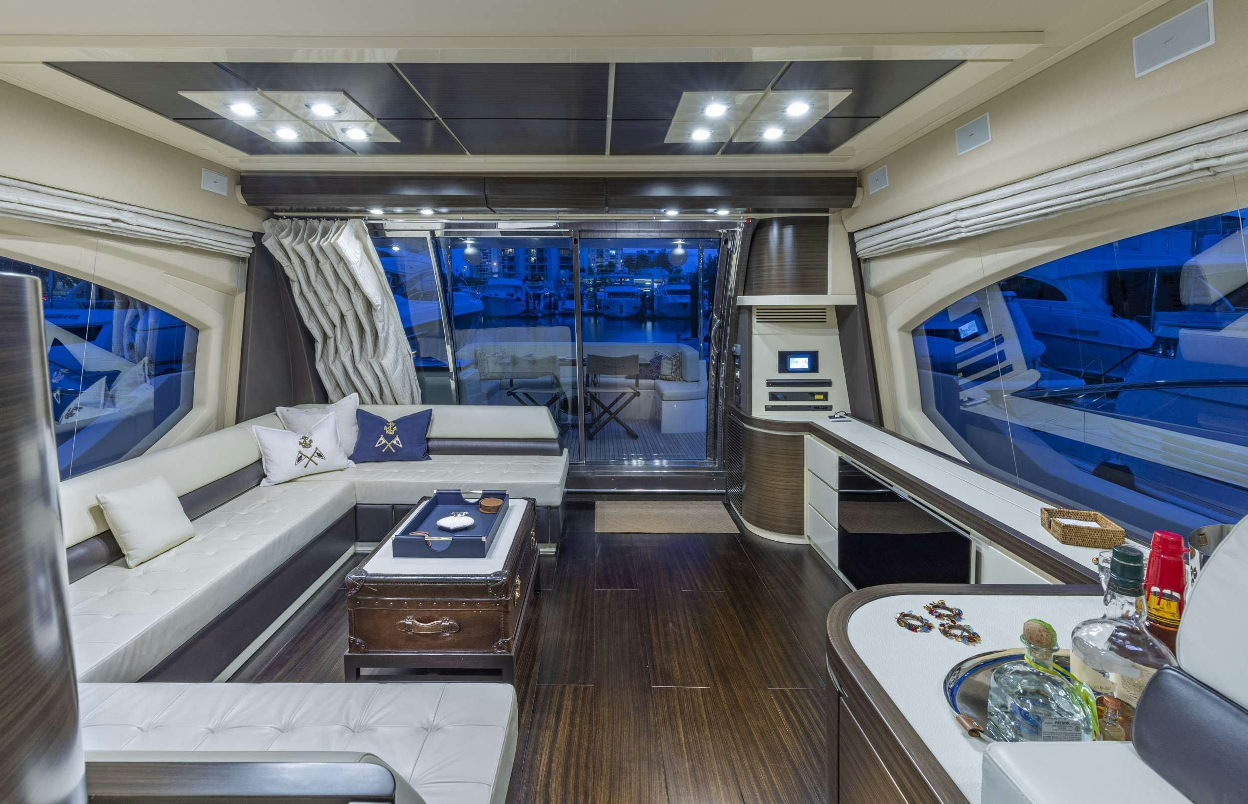 a room with a large window and a table with a couch and a table with a glass wall aboard DESSERT FIRST Yacht for Charter