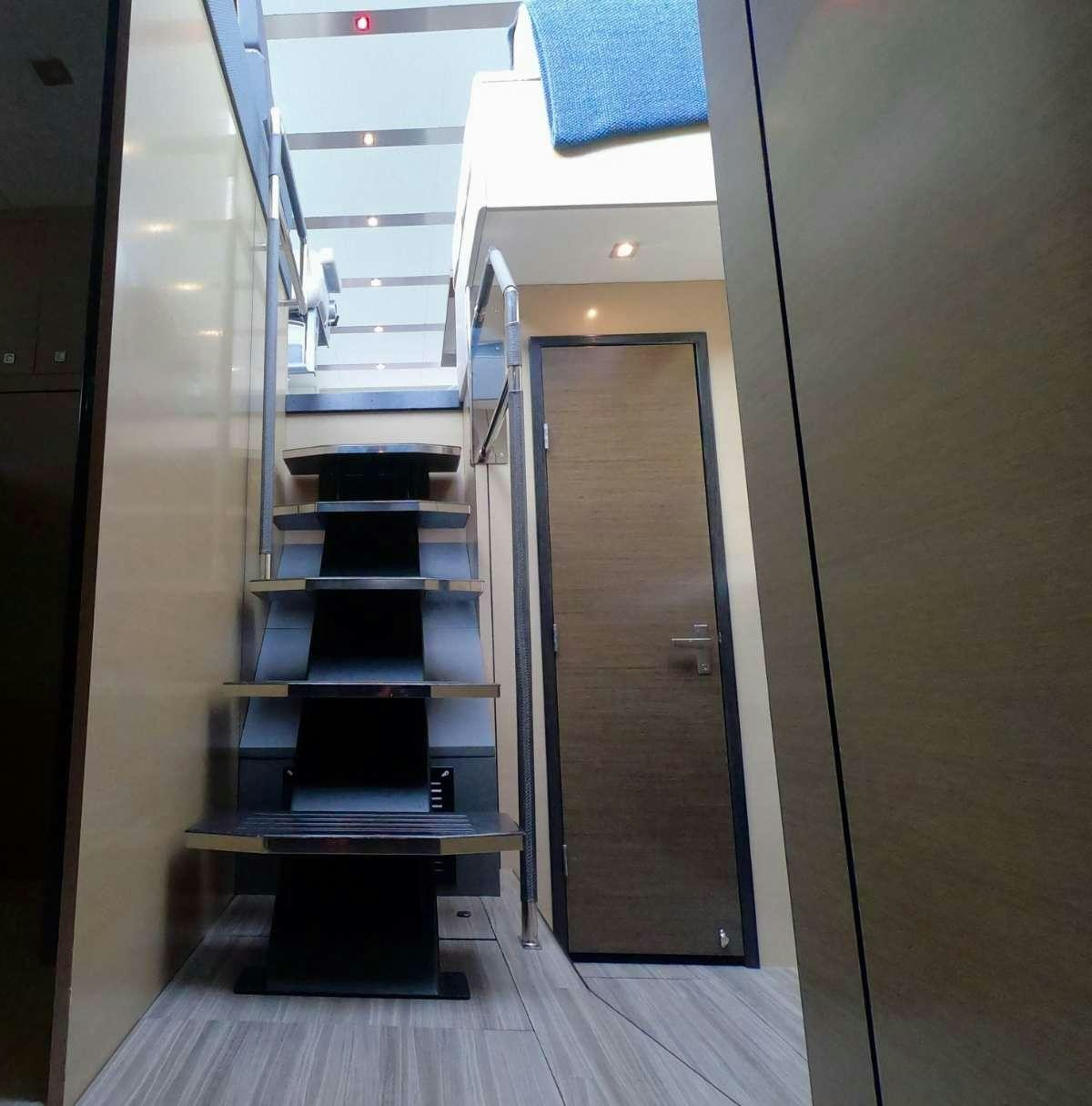 a hallway with a door and a ladder aboard RIO Yacht for Charter