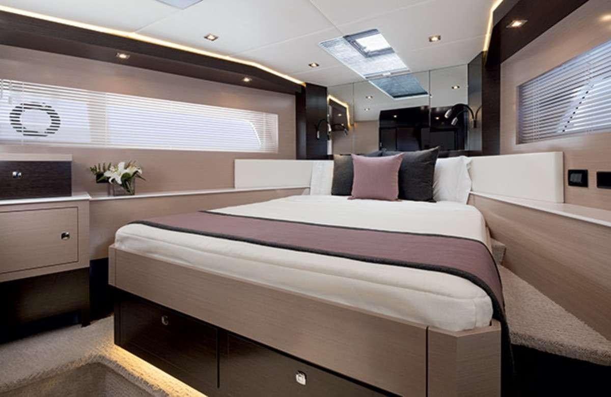 a room with a bed and a desk aboard RIO Yacht for Charter
