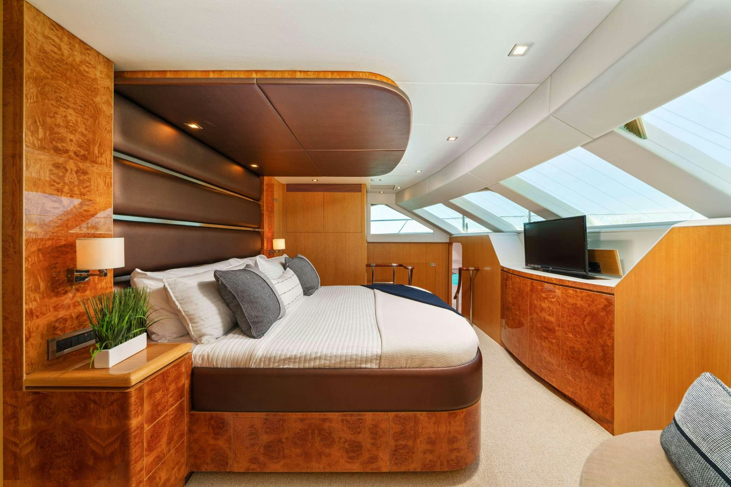 a bedroom with a bed and a tv aboard INDIGO Yacht for Charter
