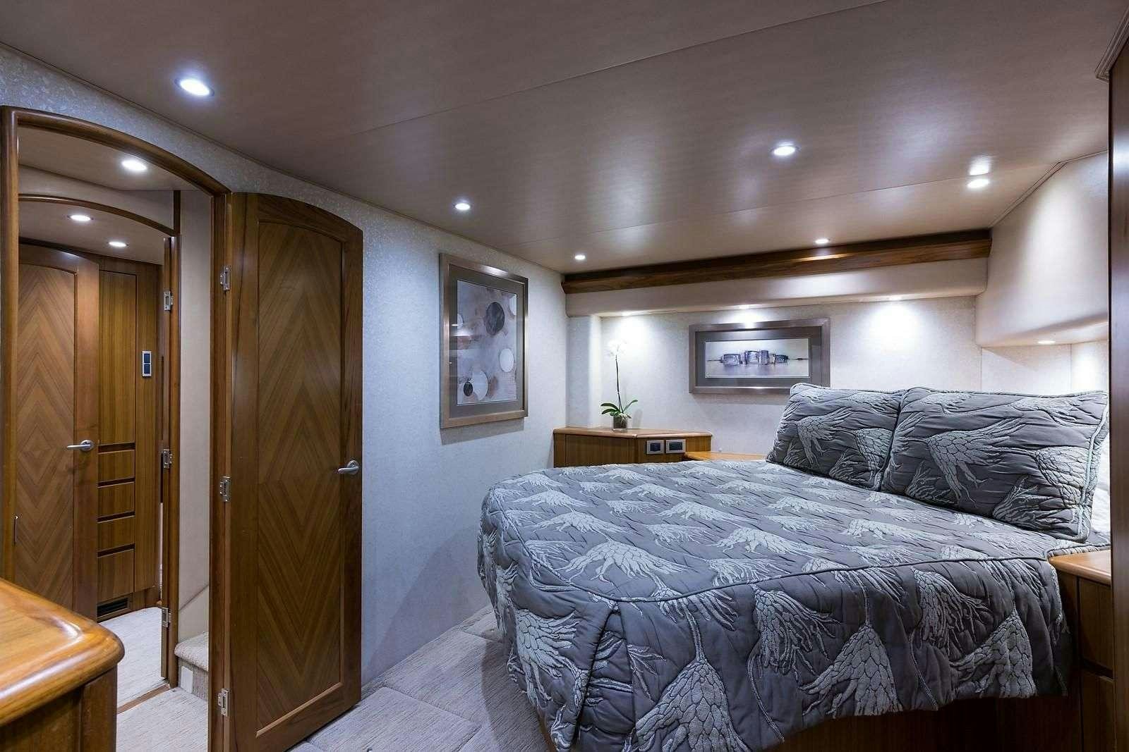 a bedroom with a bed and a wood door aboard JAYWALKER Yacht for Charter