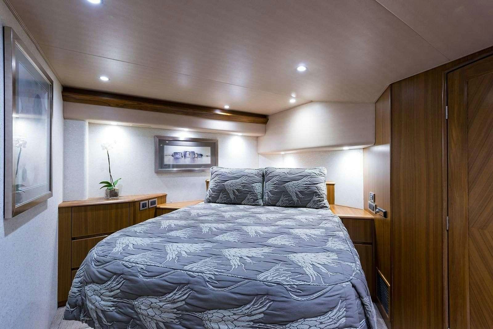 a bed with a blue comforter aboard JAYWALKER Yacht for Charter