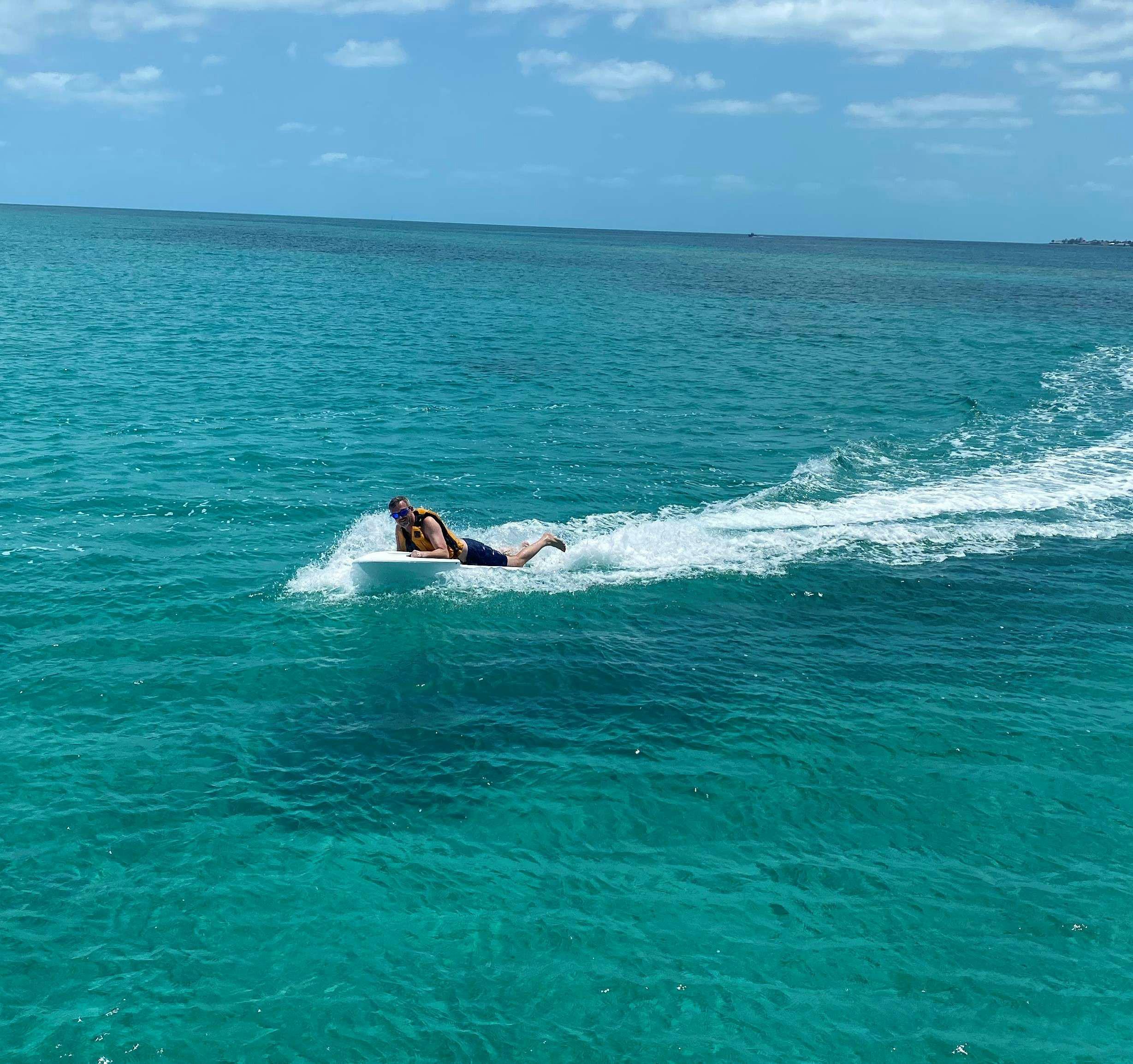 a surfer riding a small wave aboard MARCH DRAGON Yacht for Charter