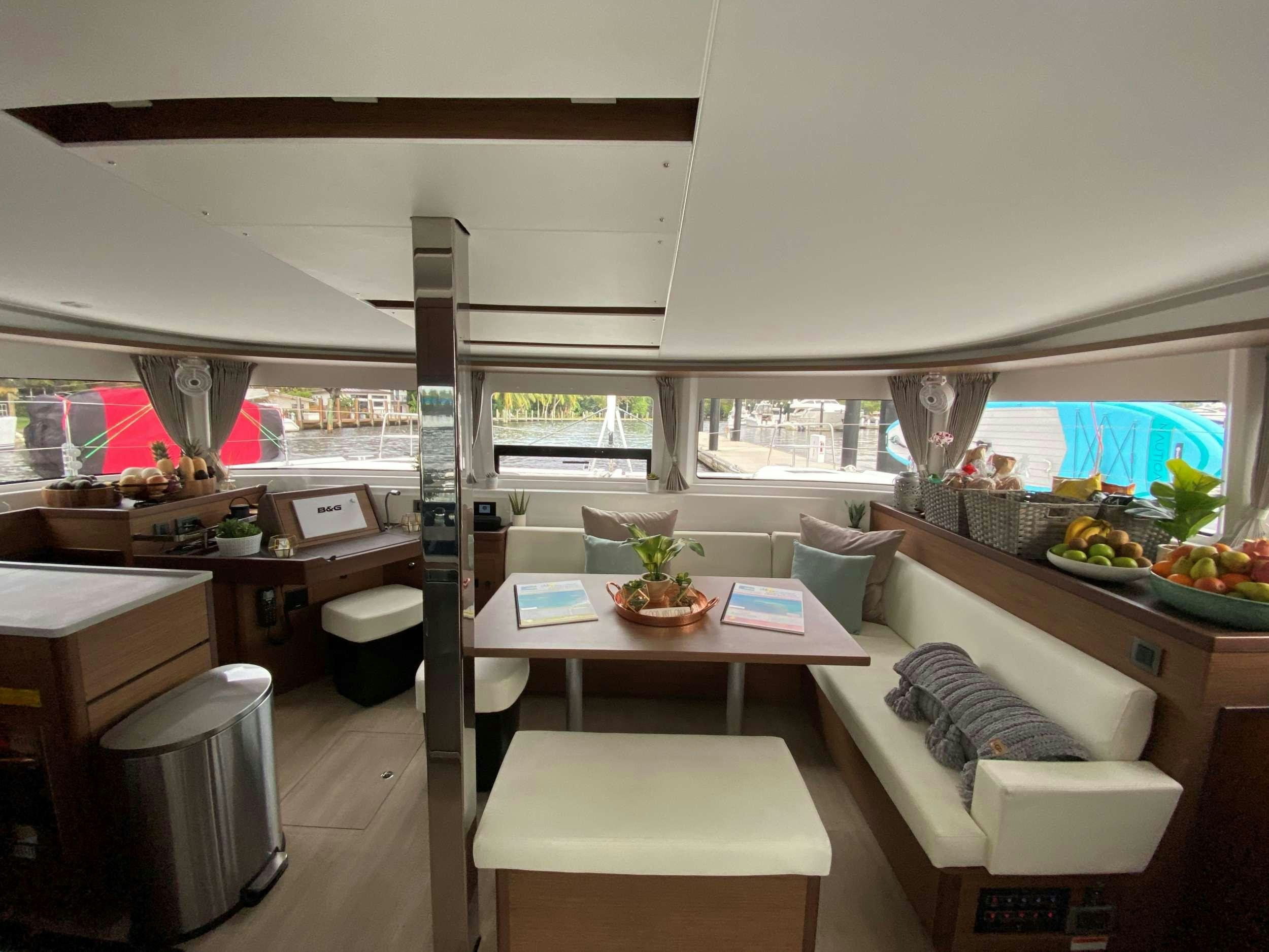 a room with a table and couches aboard MARCH DRAGON Yacht for Charter