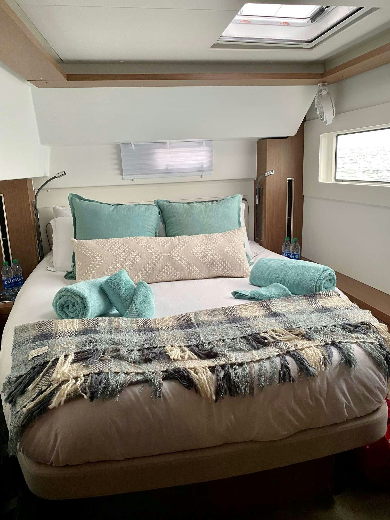 a bed with a blue pillow aboard MARCH DRAGON Yacht for Charter