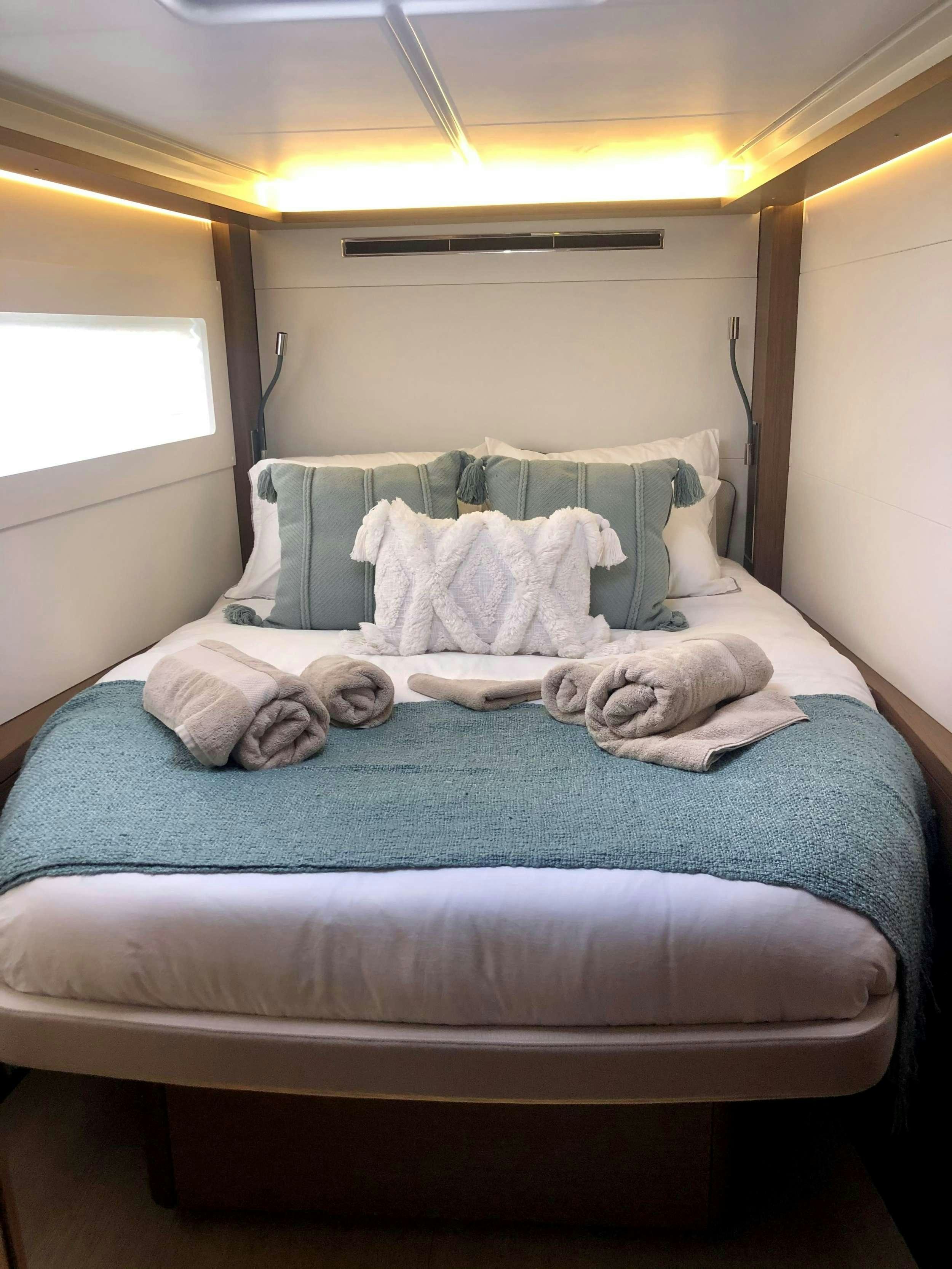 a bed with blue sheets aboard MARCH DRAGON Yacht for Charter