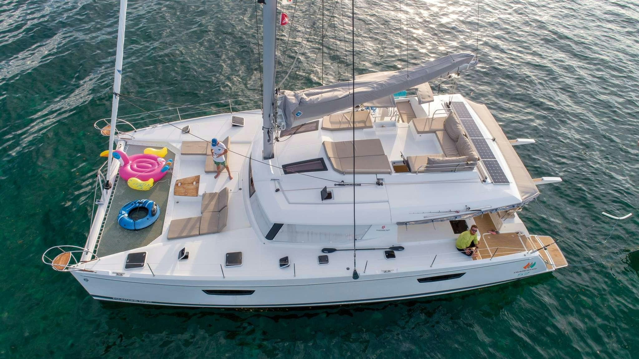 a white boat with a sail on the water aboard Cruising TW52 Yacht for Charter