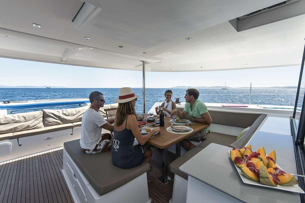 a group of people sitting at a table on a boat aboard Cruising TW52 Yacht for Charter