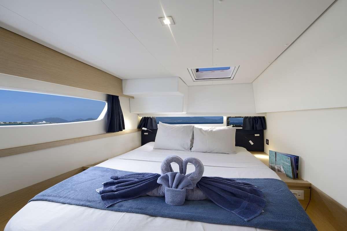 a bed with a blue blanket aboard Cruising TW52 Yacht for Charter