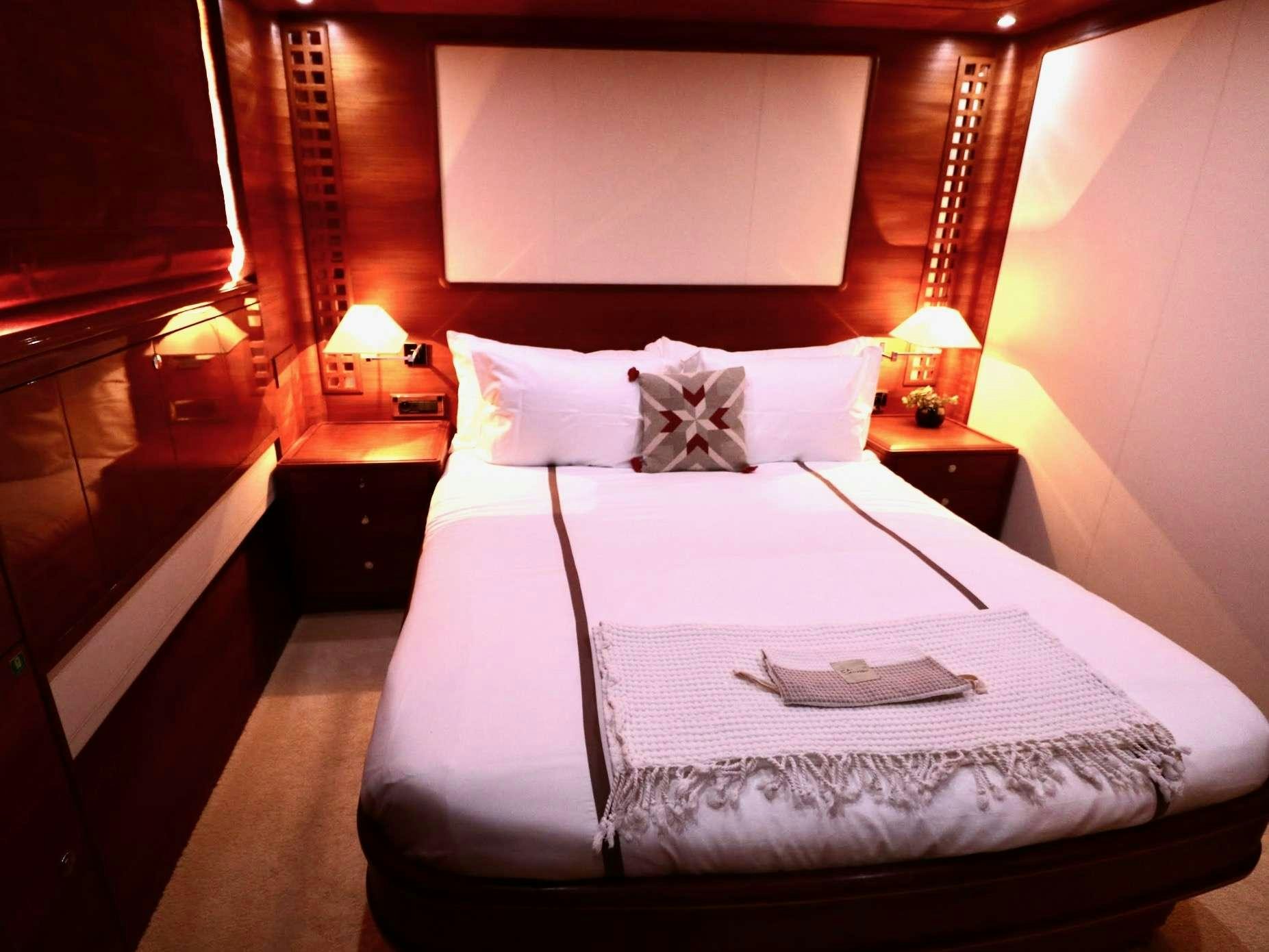 a bed with a white sheet and pillows on it aboard ECLIPSE 114 Yacht for Charter