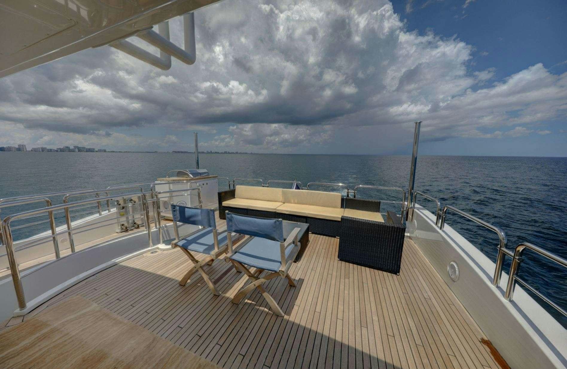 a deck with chairs and tables on it by the water aboard VALERE Yacht for Charter