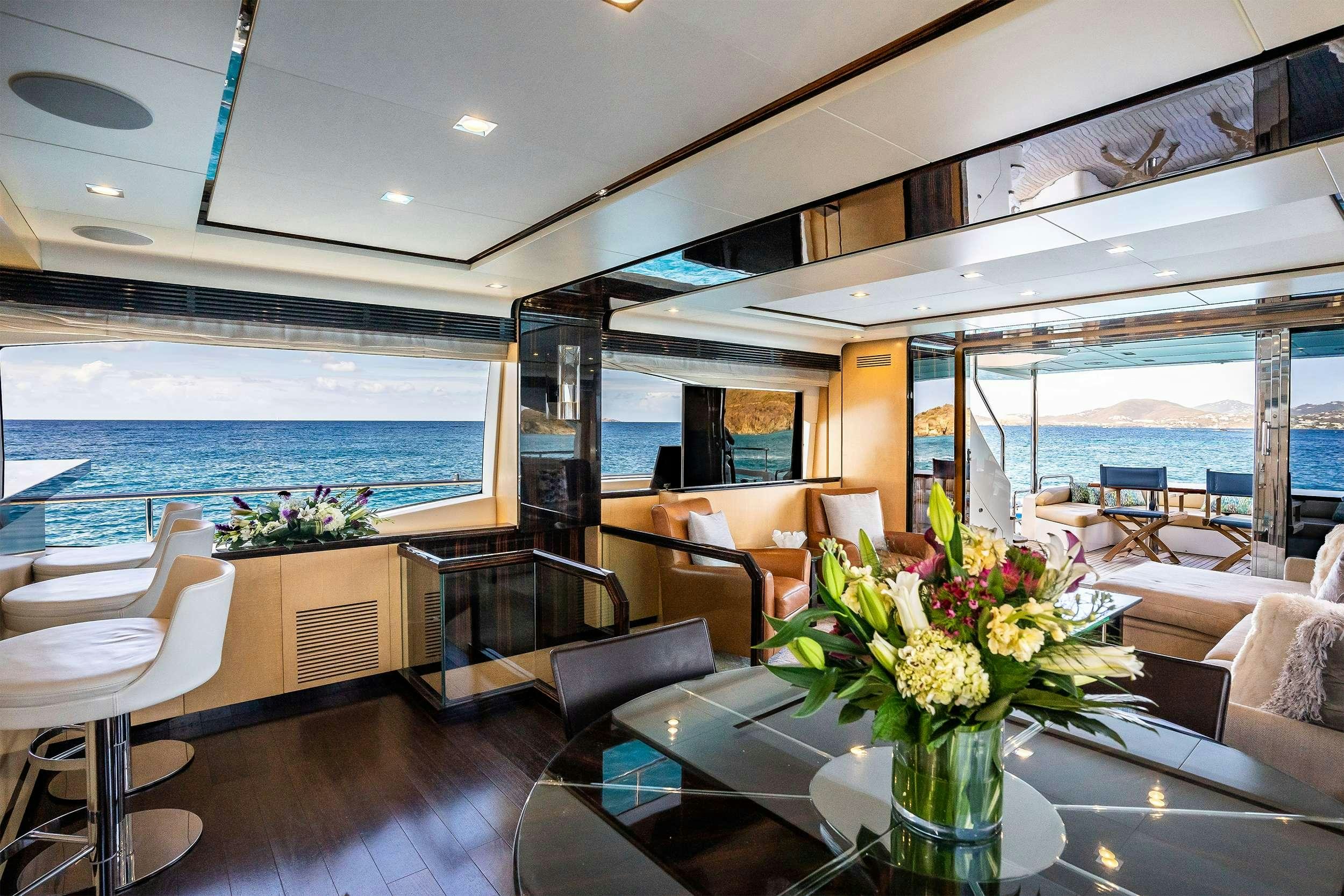 a room with a table chairs and a view of the ocean aboard VALERE Yacht for Charter