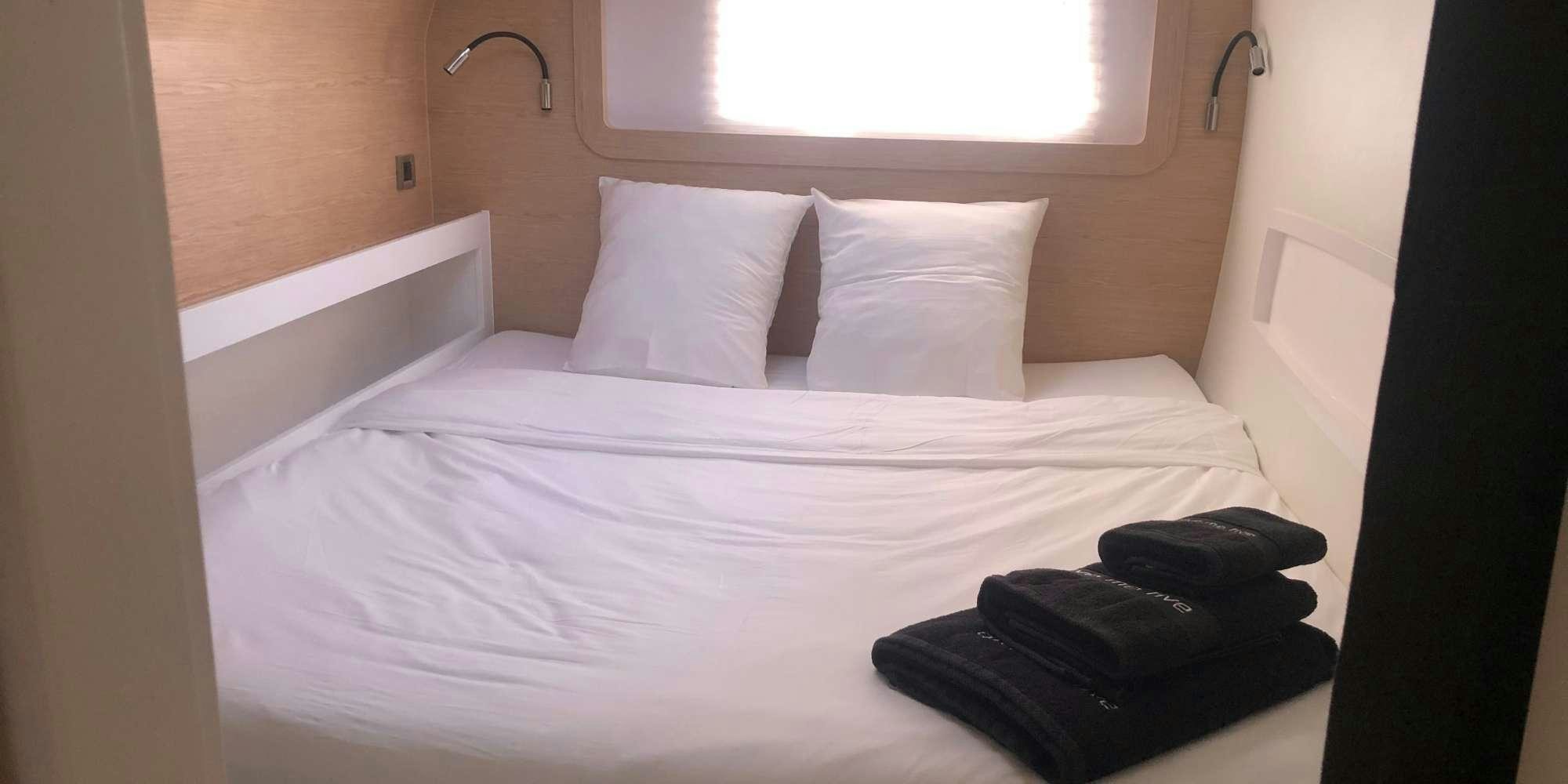 a bed with white sheets aboard GIVE ME FIVE Yacht for Charter