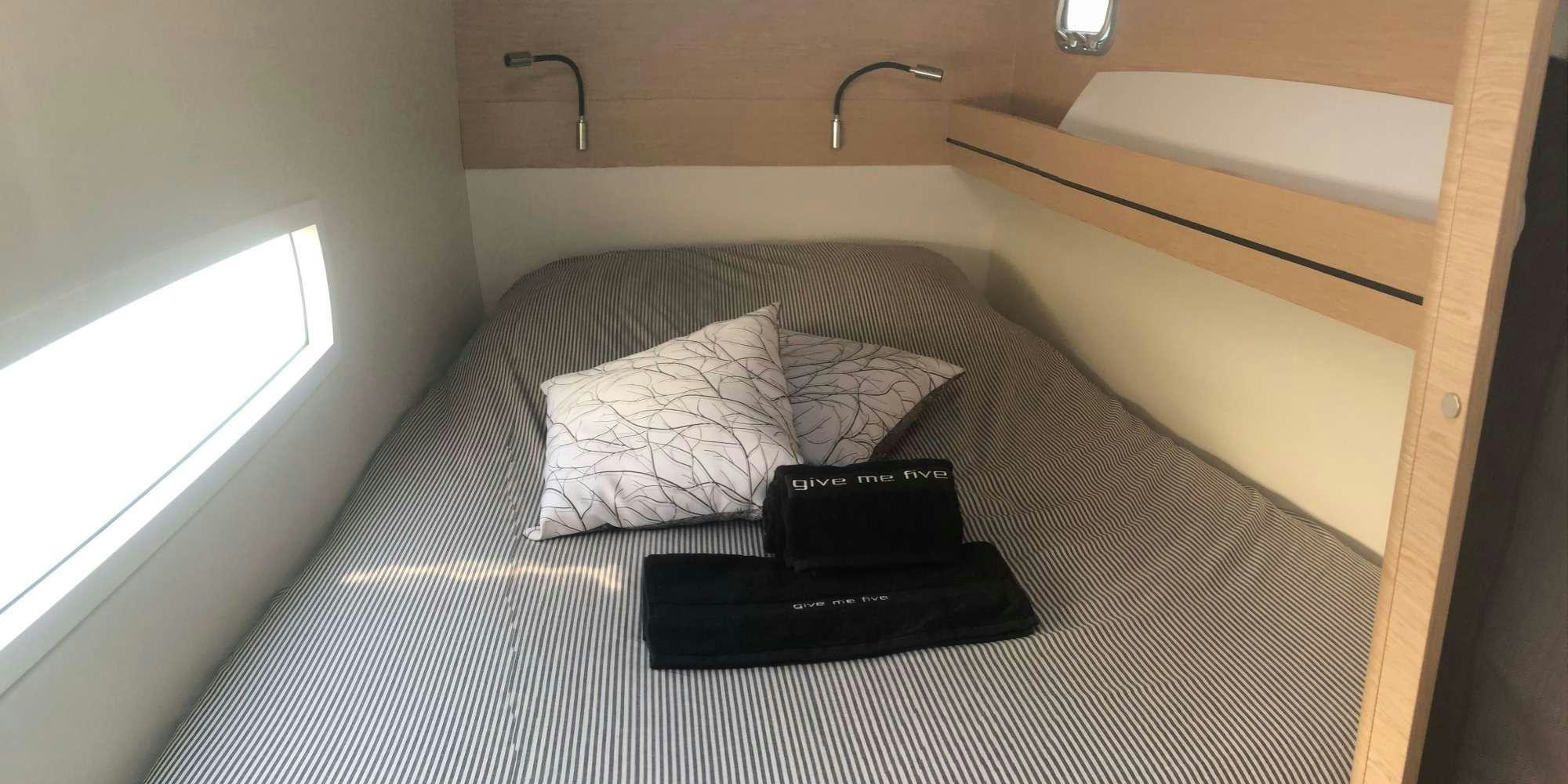 a bed with a phone on it aboard GIVE ME FIVE Yacht for Charter