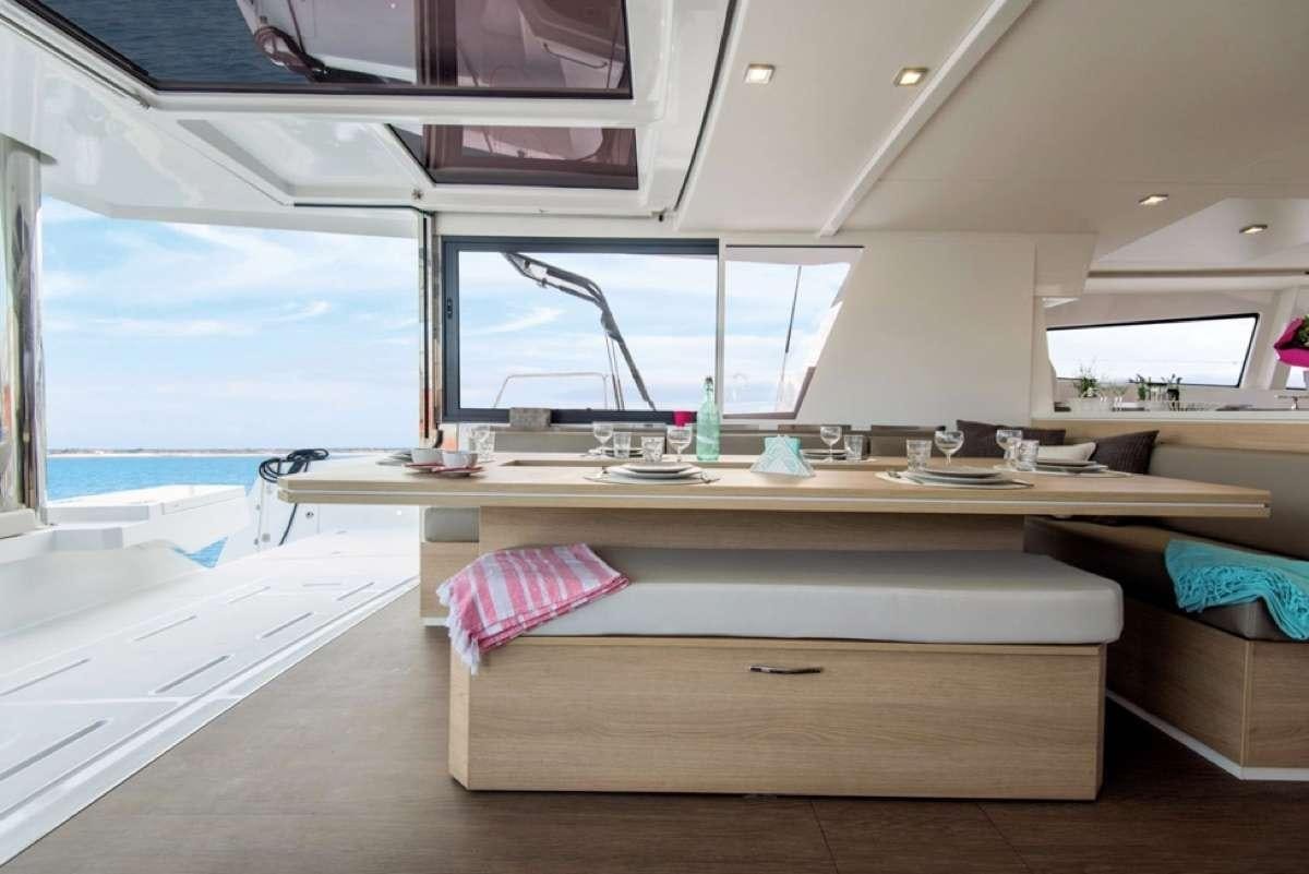 a room with a table and a window aboard Crystal Dreams Yacht for Charter