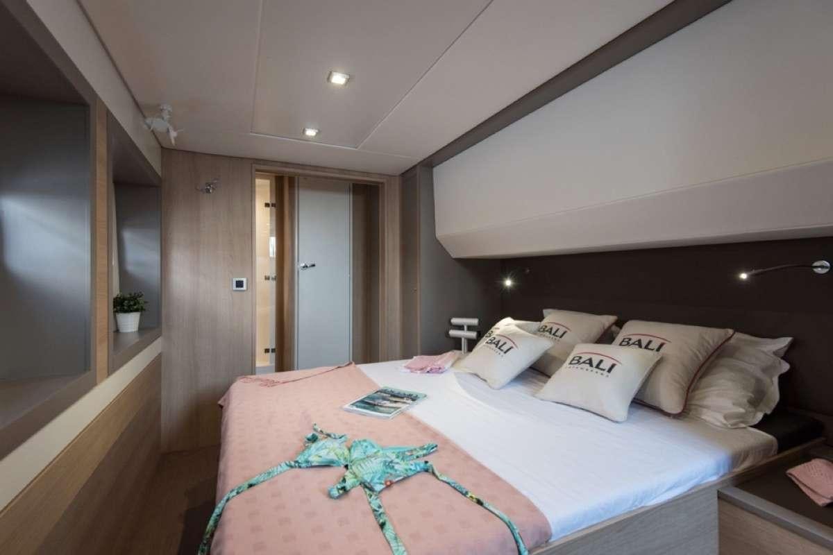 a bed with a blue blanket aboard Crystal Dreams Yacht for Charter
