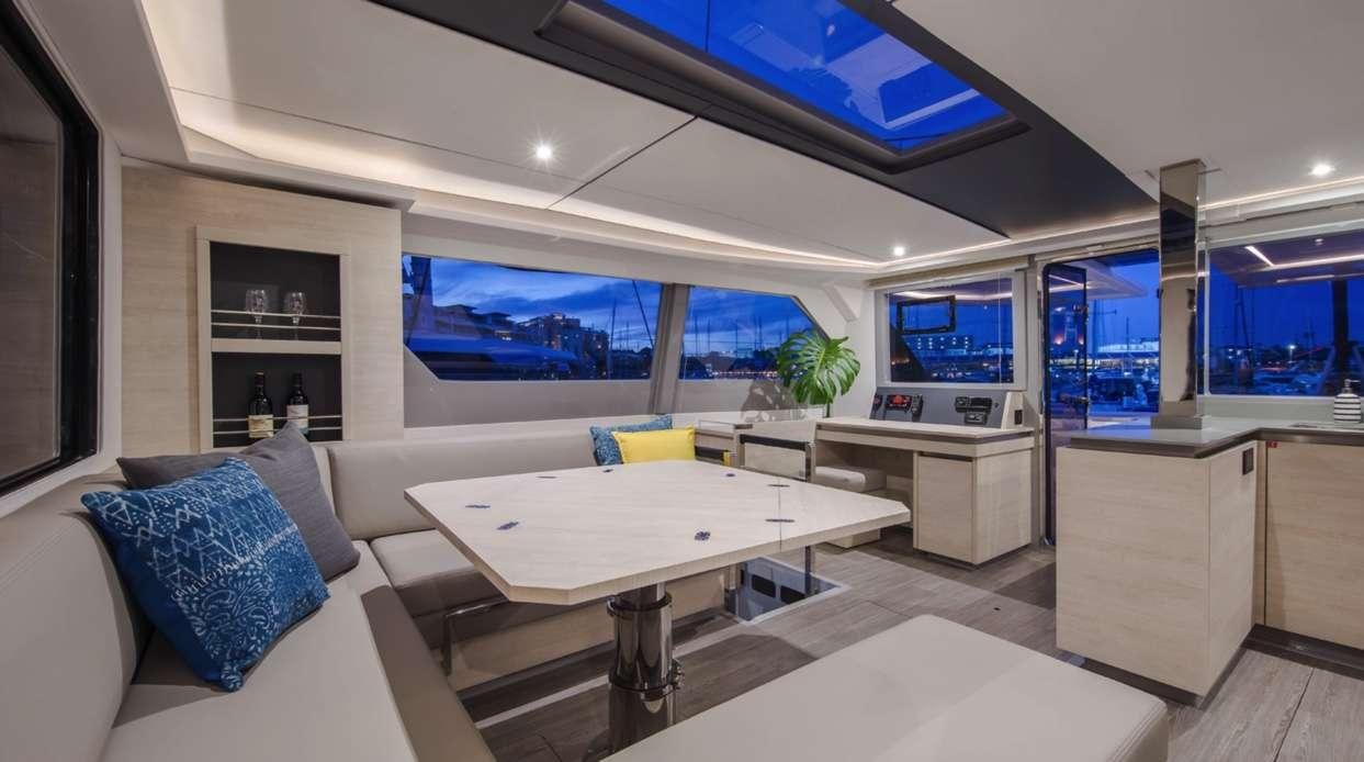 a room with a table and a couch aboard Atumavu Yacht for Charter