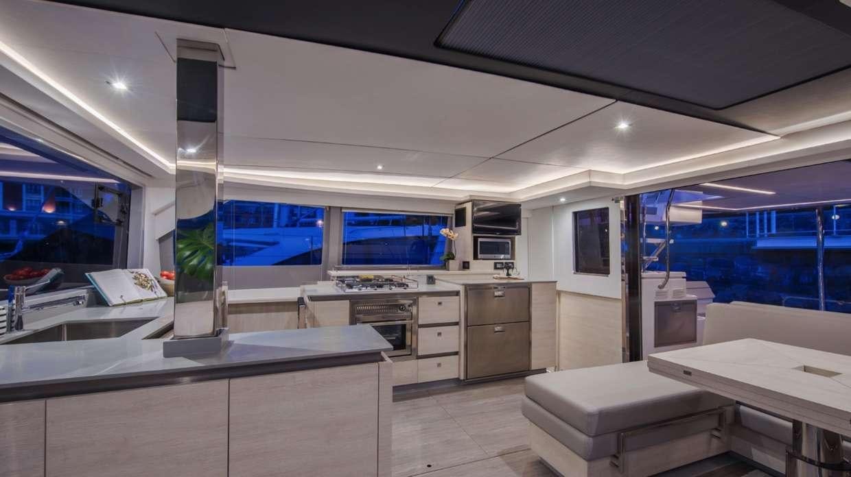 a room with a large window and a counter with a view of the water aboard Atumavu Yacht for Charter