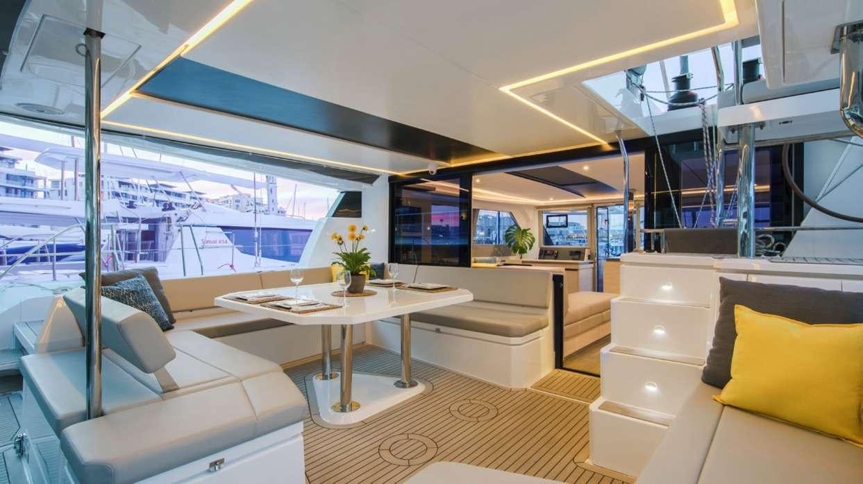 a room with a table and couches aboard Atumavu Yacht for Charter