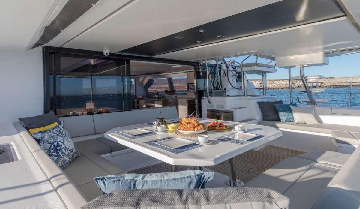 a boat with a table and chairs aboard Atumavu Yacht for Charter